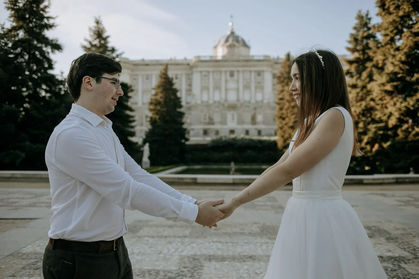 Los novios se dan las manos en la Plaza de Oriente, con el Palacio Real detrás
