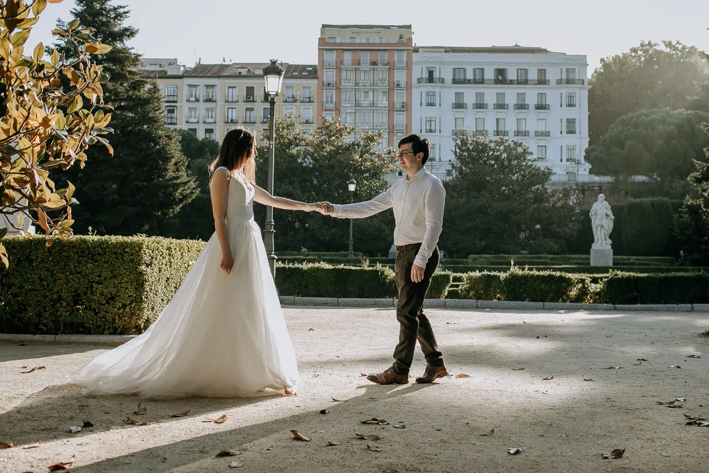 Los novios se dan la mano en un paseo soleado del jardín, Madrid