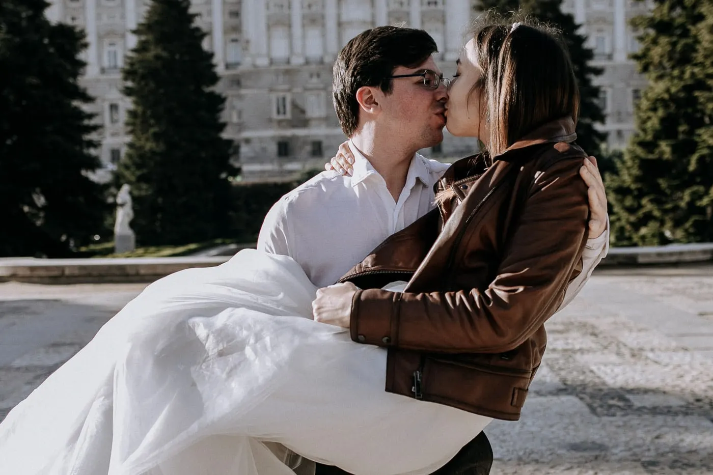 El novio besa a la novia mientras la sostiene en brazos