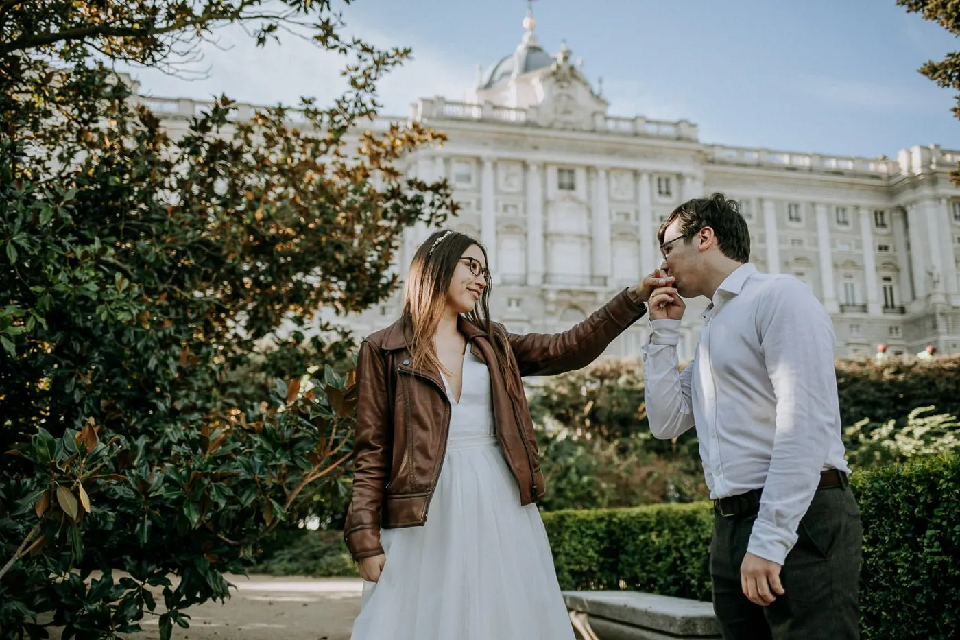El novio besa la mano de la novia con el Palacio Real detrás, Madrid
