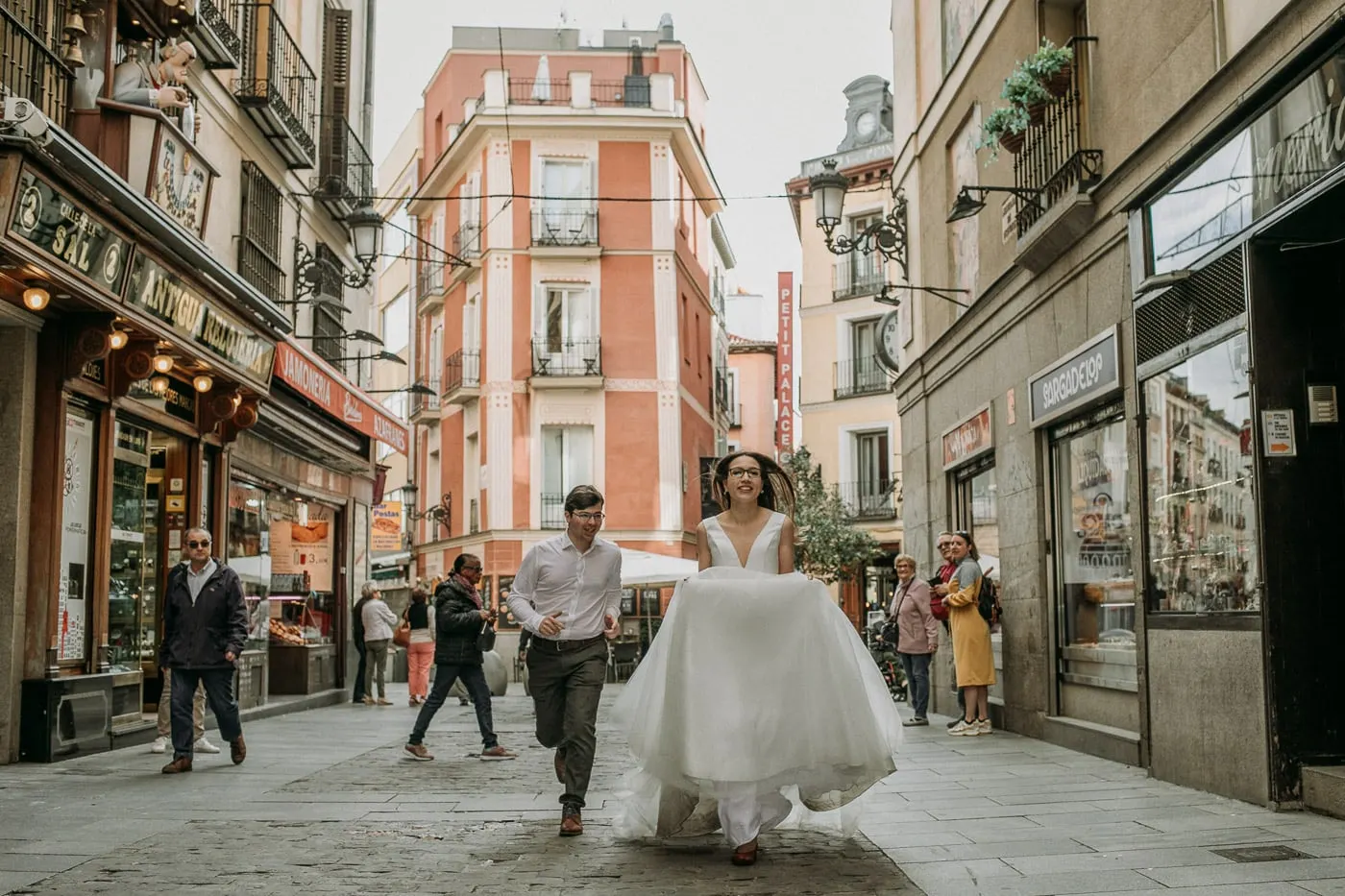 Los novios corren por una calle comercial del centro de Madrid