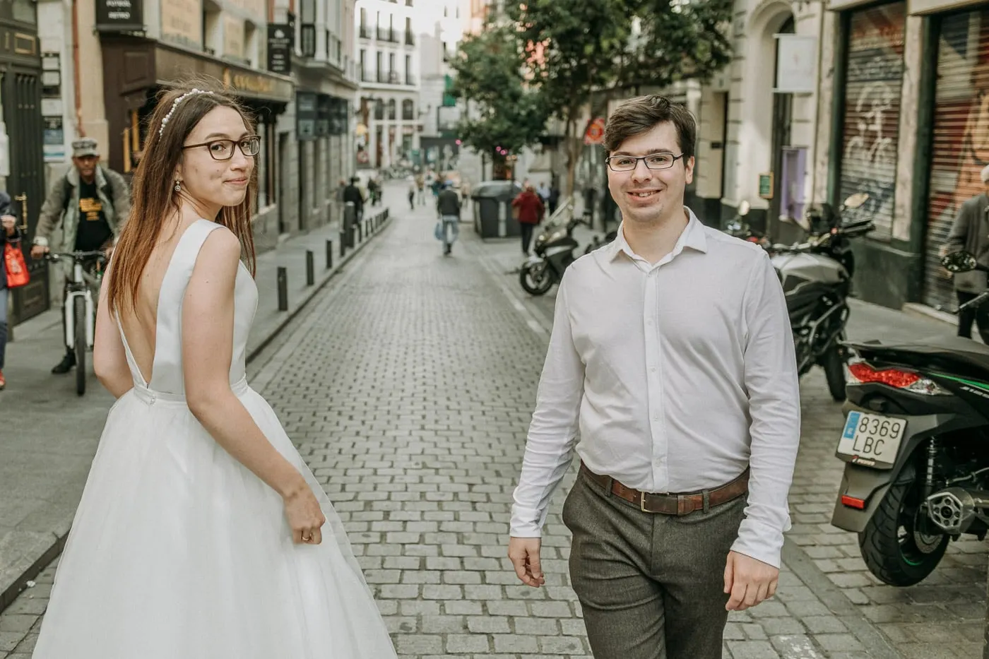 La novia mira atrás hacia el novio en una calle adoquinada, Madrid