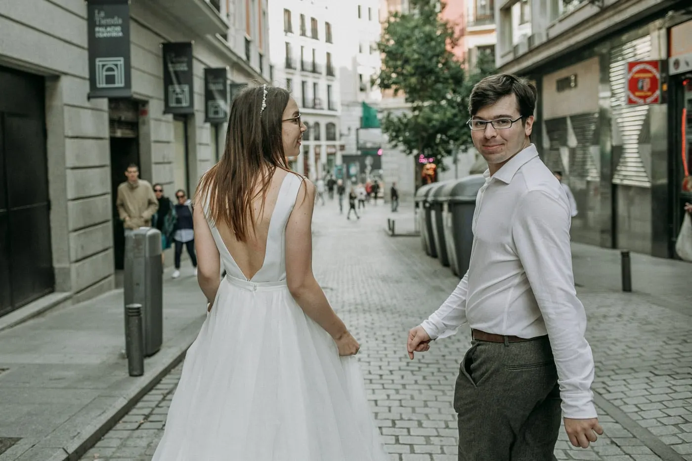Los novios se giran para mirarse en una calle peatonal