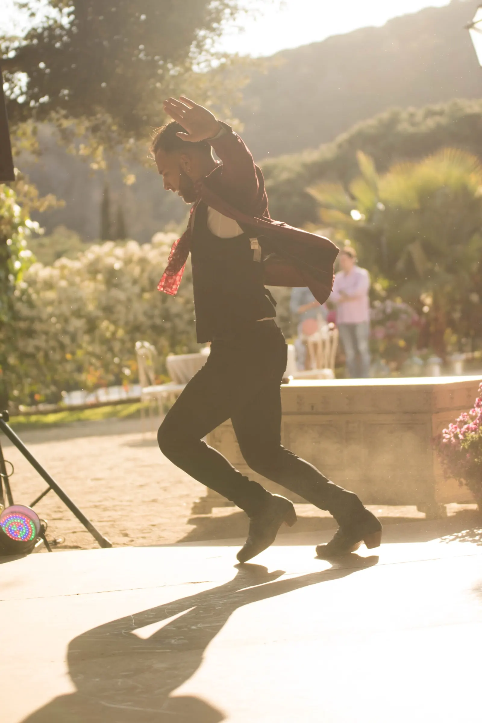 Un bailaor de flamenco zapatea en el patio a contraluz dorado, en una masía de Girona