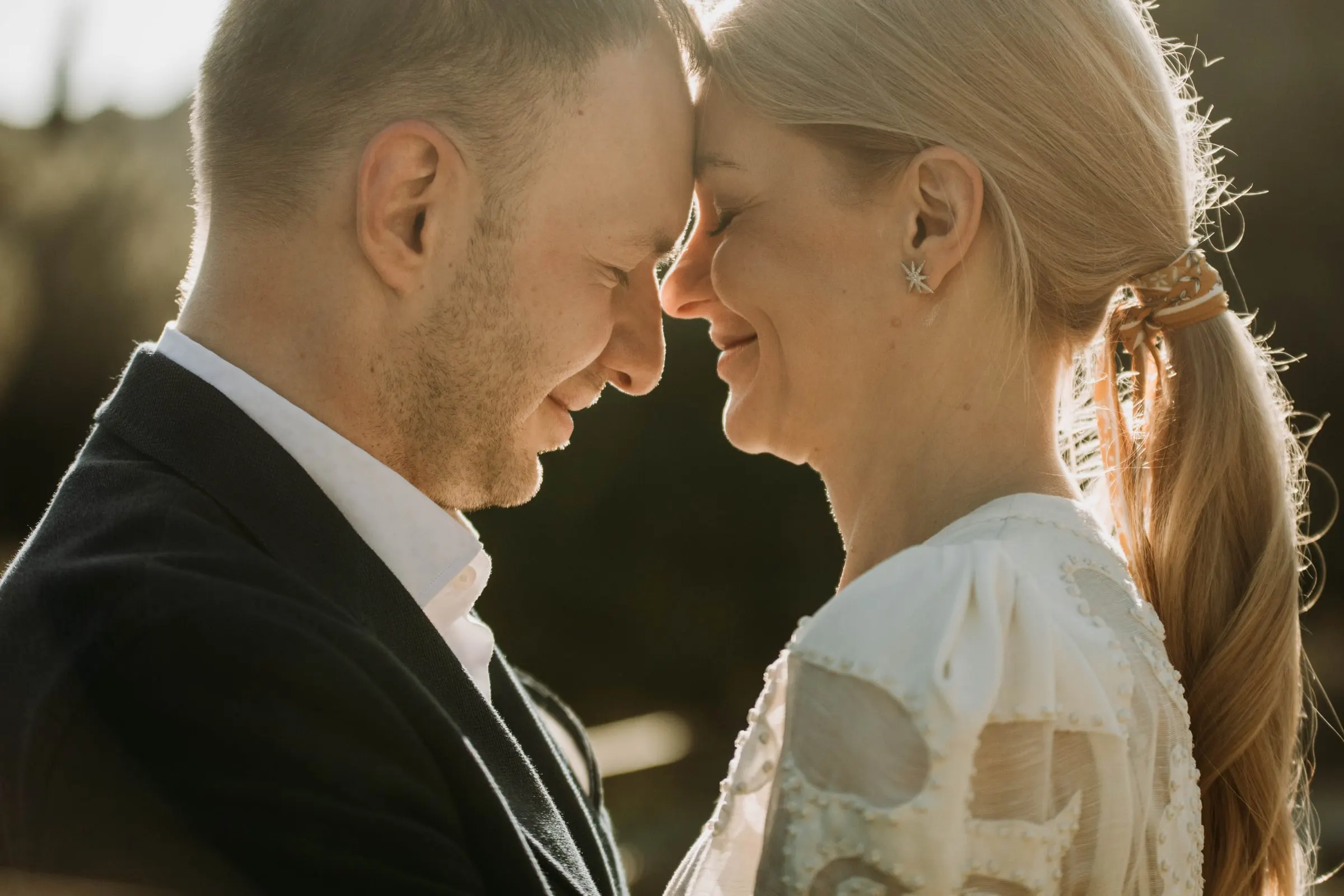 Los novios frente con frente y con los ojos cerrados, a contraluz suave, en una masía de Girona