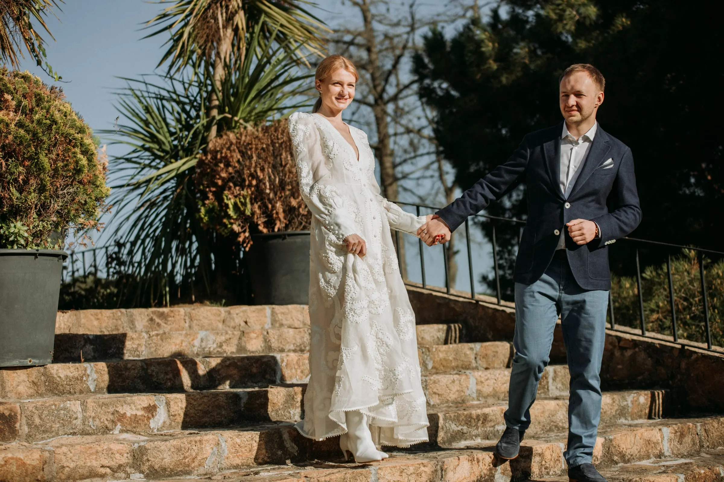 Los novios bajan de la mano la escalinata de piedra del jardín de una masía de Girona