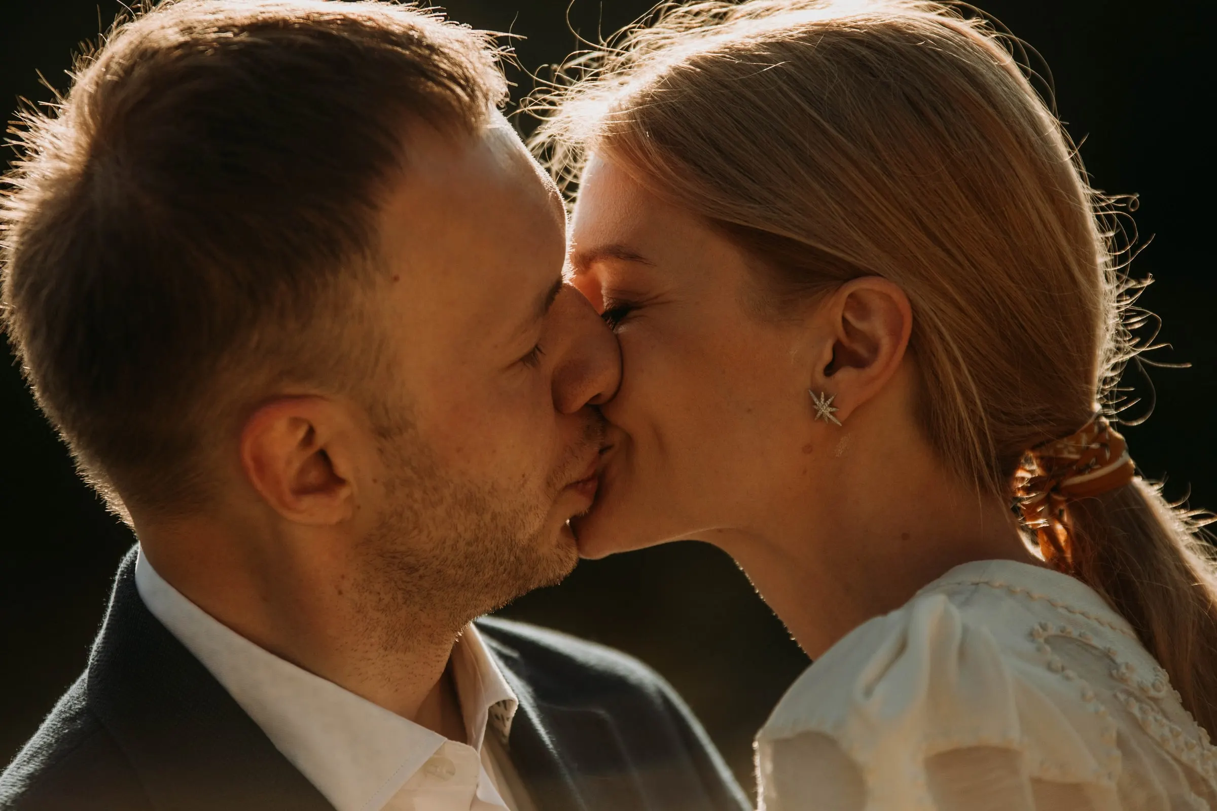 Primer plano del beso de los novios con la luz cálida de la tarde en una masía de Girona