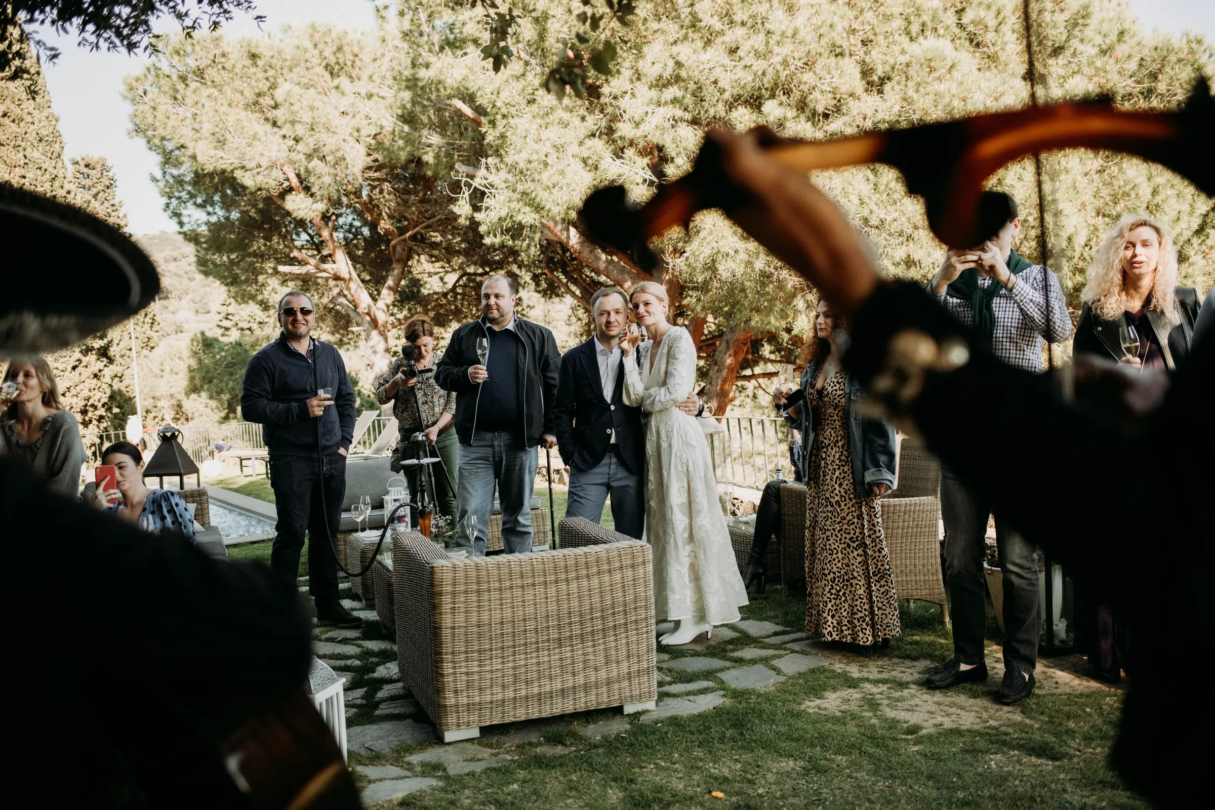 Los novios y los invitados escuchan a un violinista mariachi en el jardín de una masía de Girona