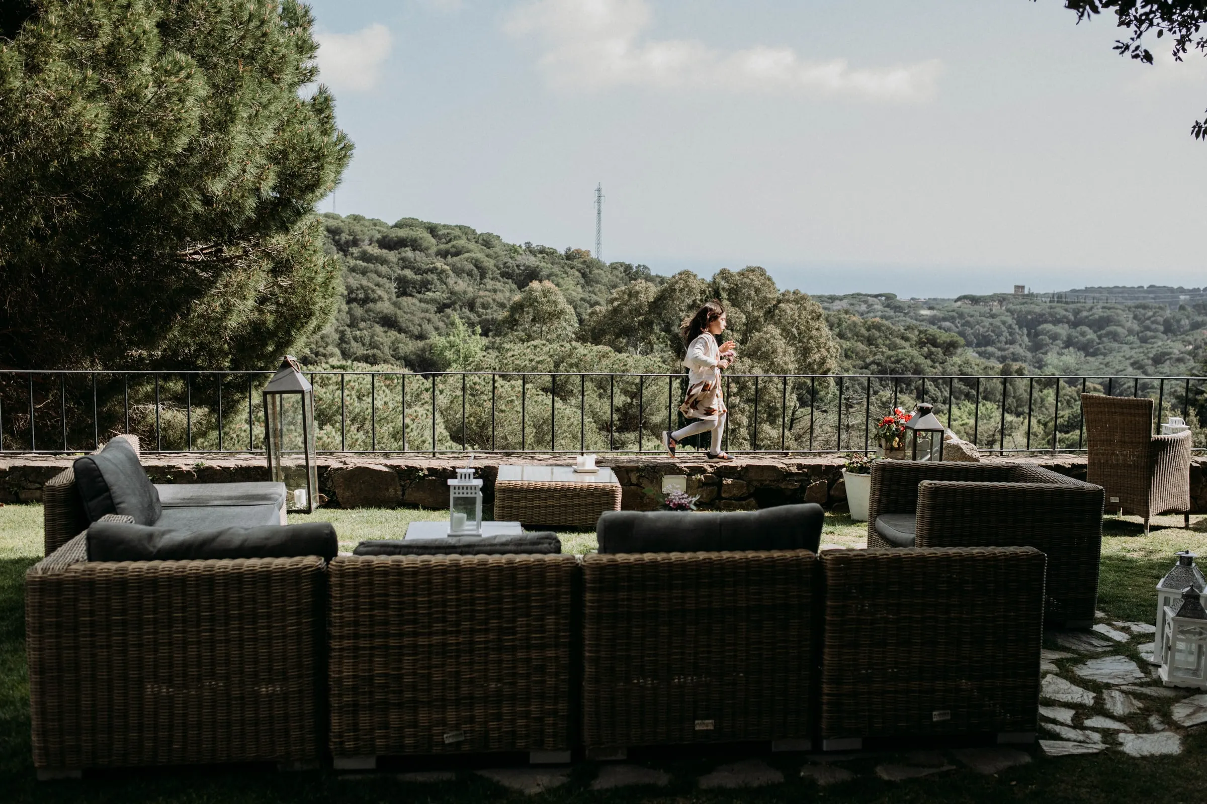 El rincón de sofás de mimbre en la terraza del jardín, con vistas a las colinas, en una masía de Girona