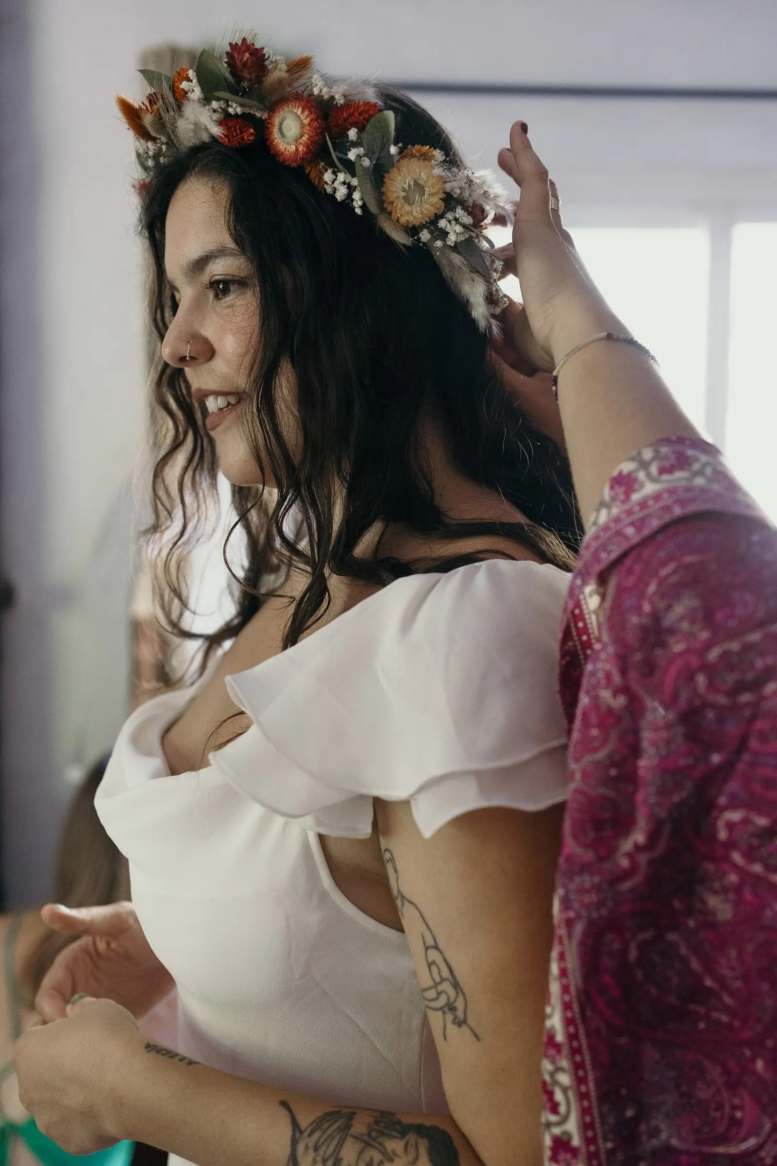 Una amiga coloca a la novia una corona de flores secas