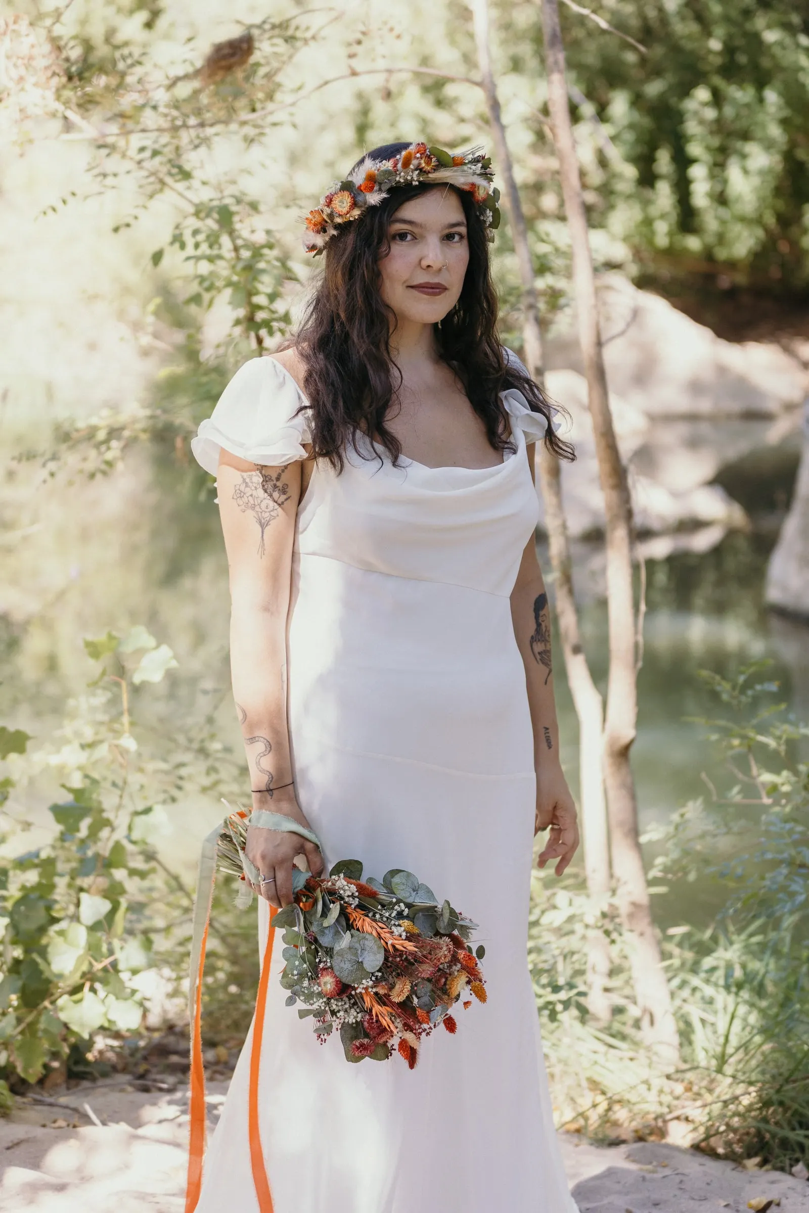 Bride in her flower crown standing in the sun beside the Guadiaro river