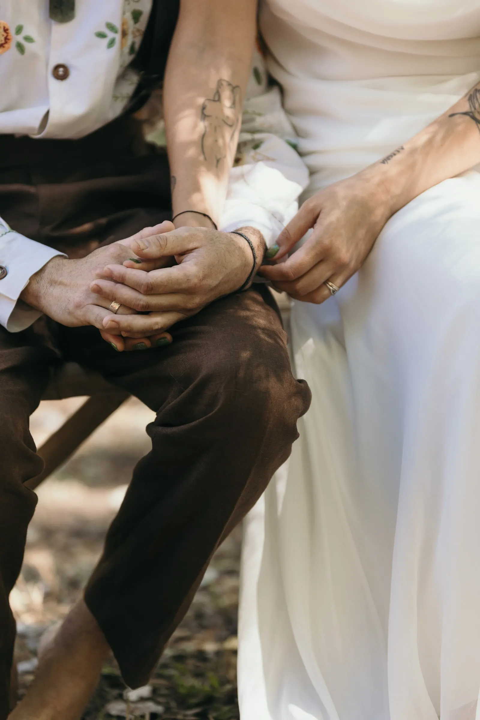 Detalle de las manos de la pareja apoyadas en el regazo