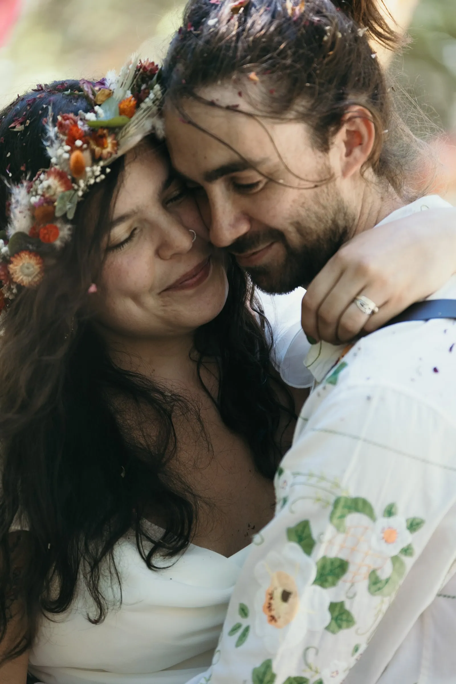 Primer plano de la pareja mejilla con mejilla, con la alianza de él a la vista