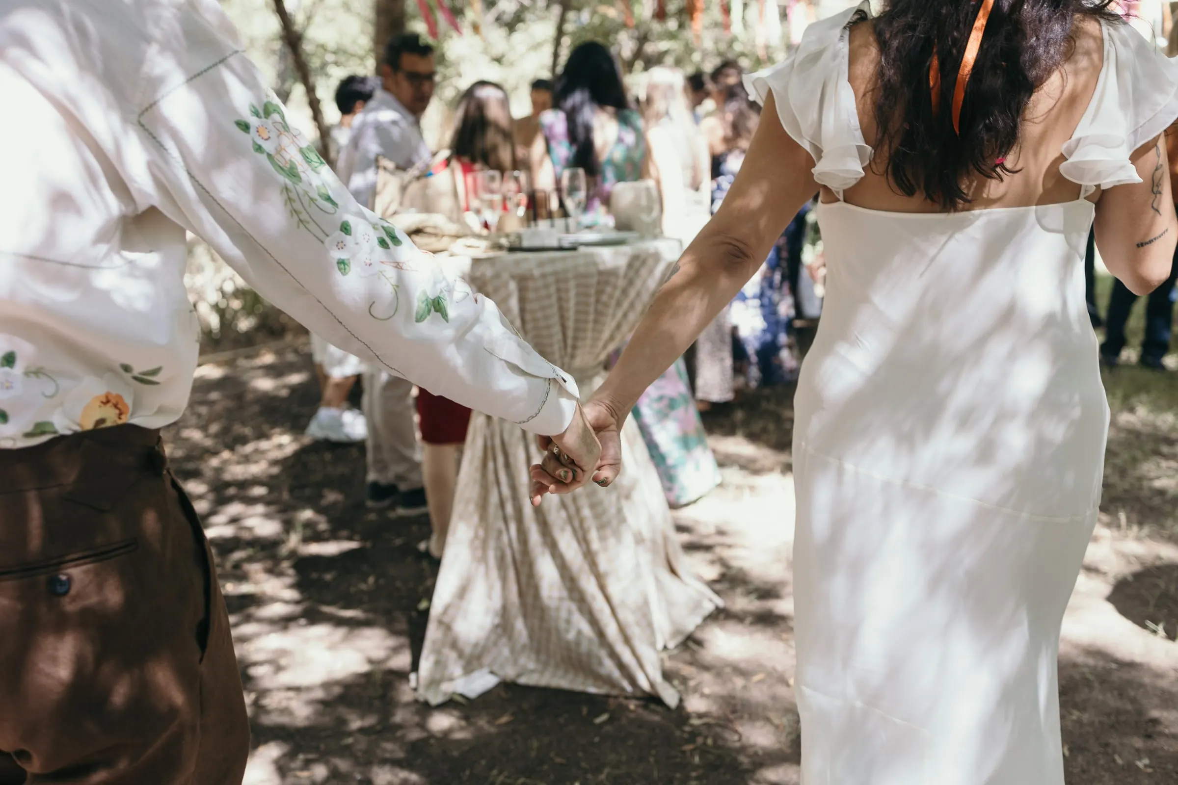 Los novios de la mano caminando entre sus invitados