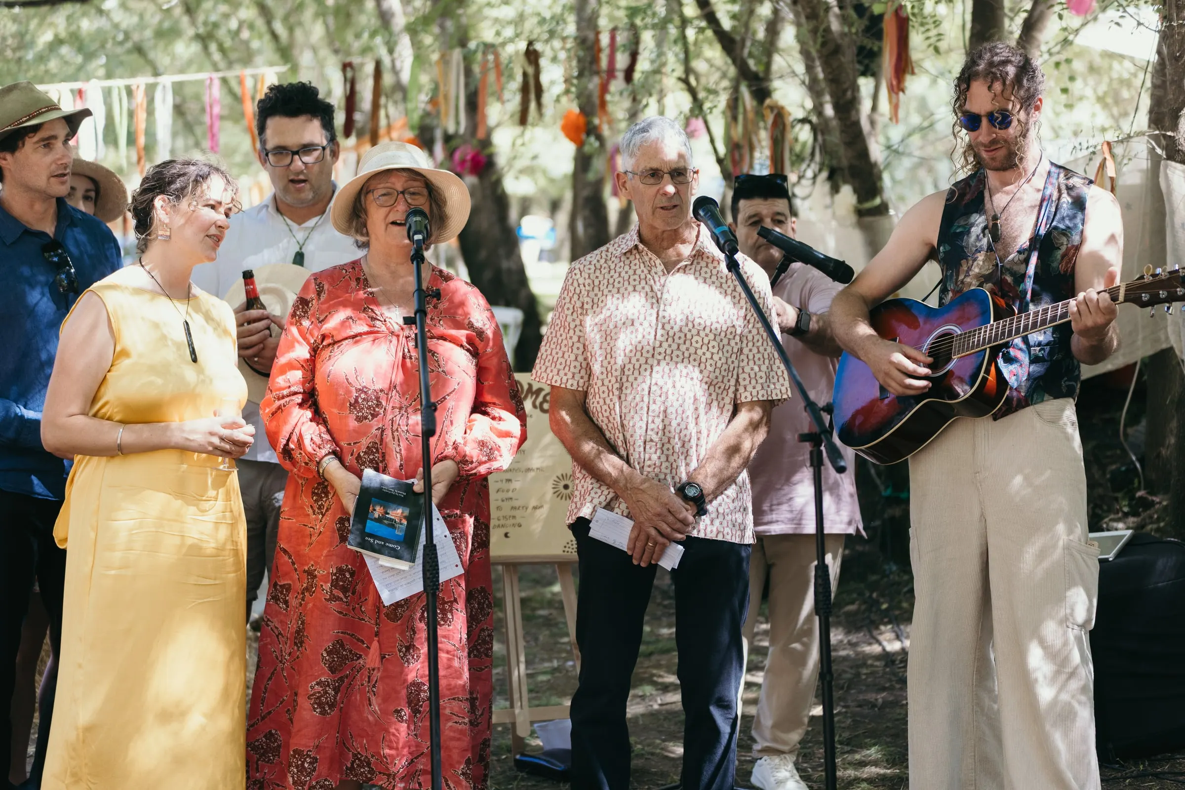 La familia canta una canción a la pareja con guitarra y micrófono
