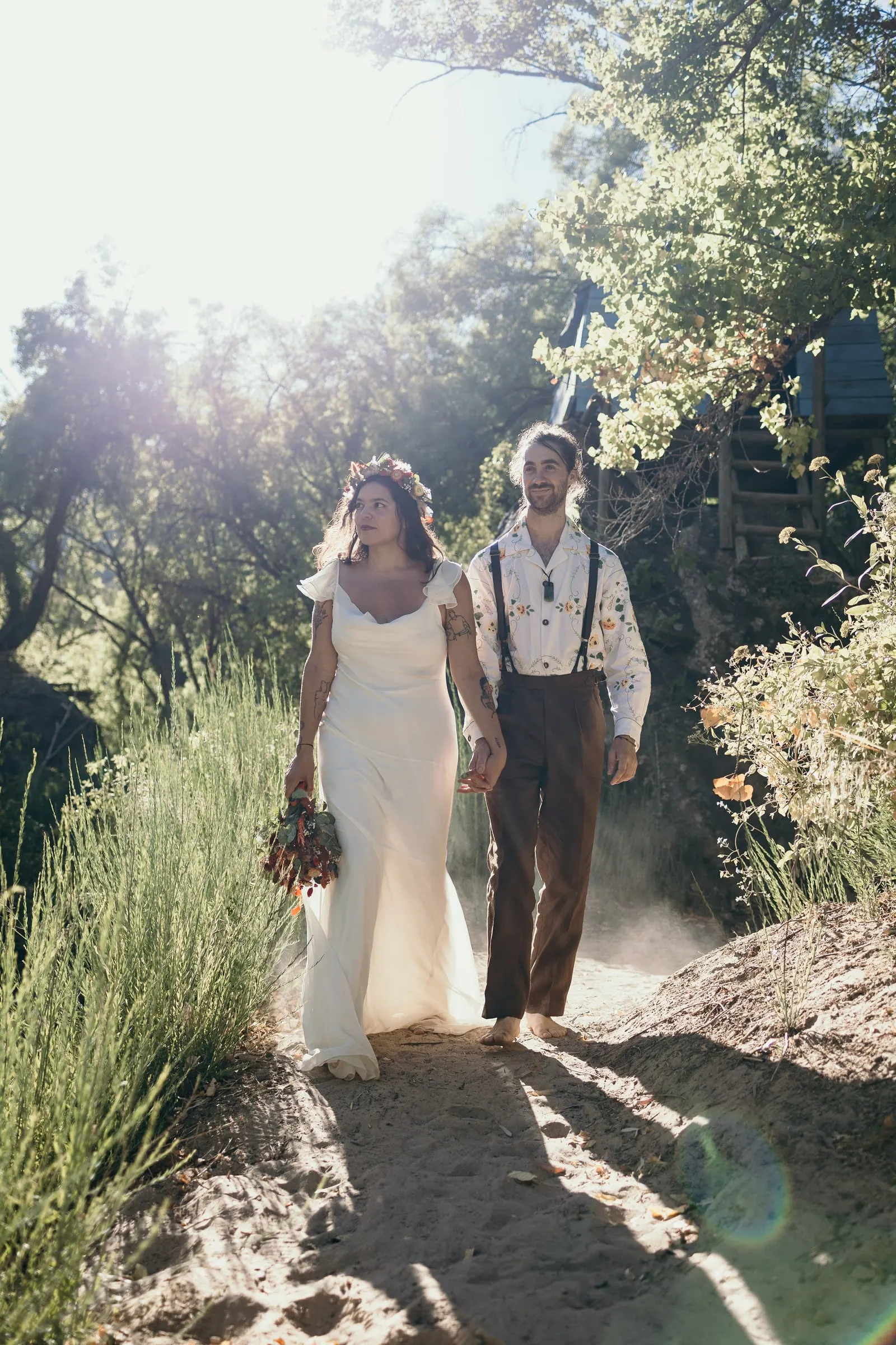 Bride and groom walking a sunlit riverside path in the Serranía de Ronda