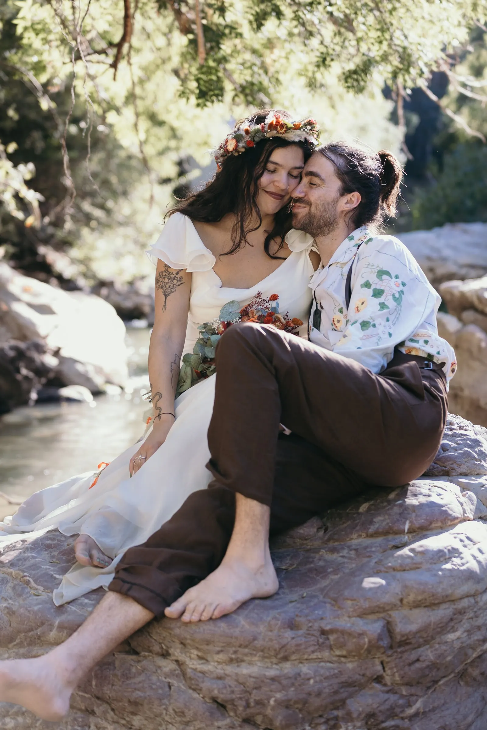 La pareja descalza sentada en una roca junto al río Guadiaro en Molino La Flor