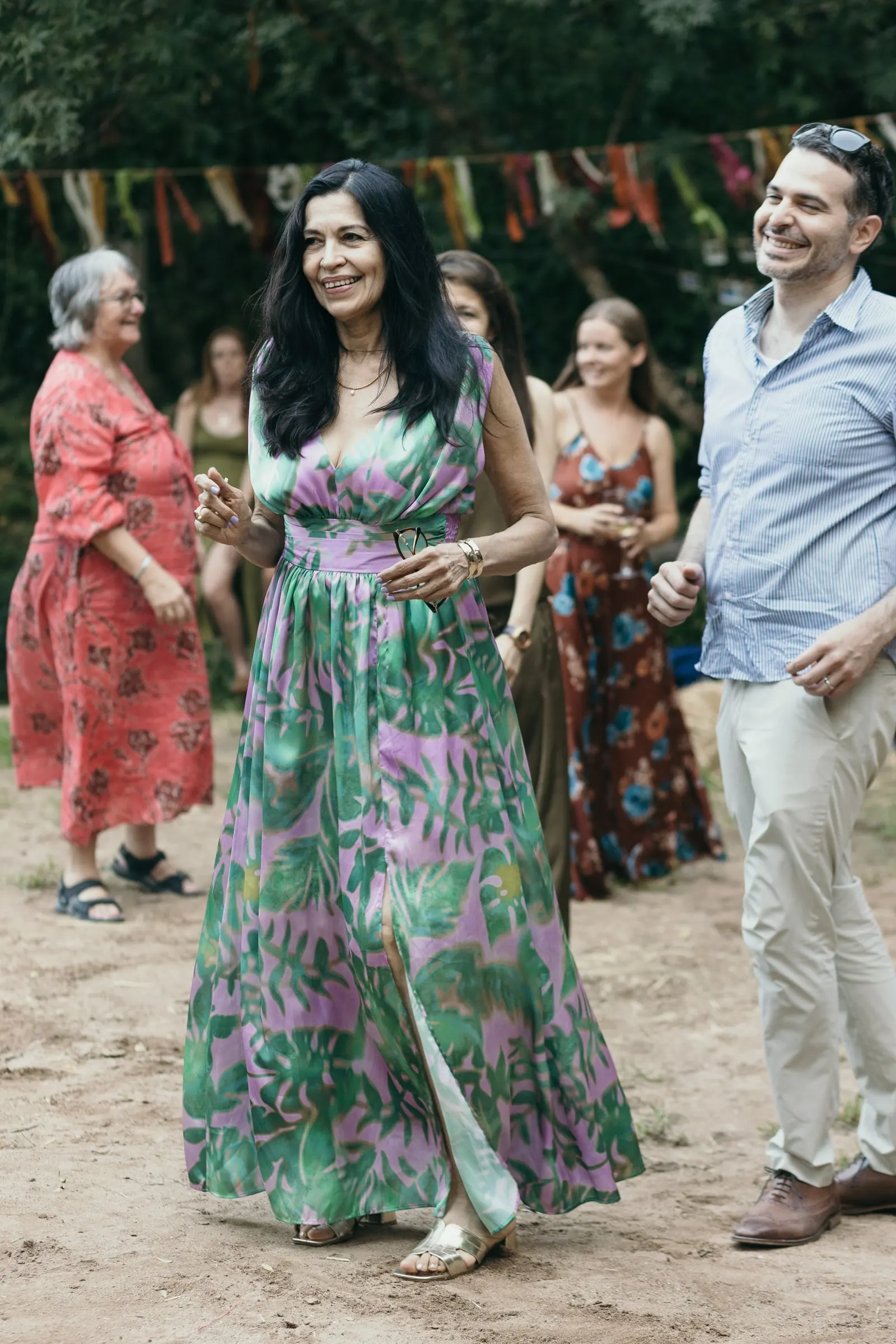 Una invitada con mono de flores baila en la fiesta