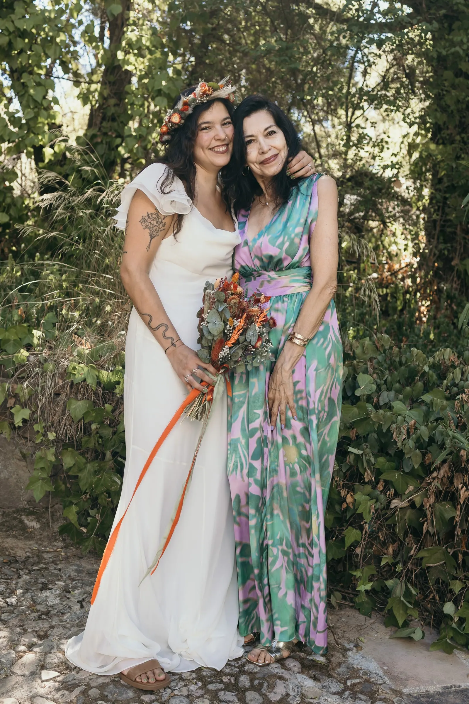 La novia y su amiga del mono de flores se arriman la una a la otra entre los árboles del valle del Guadiaro