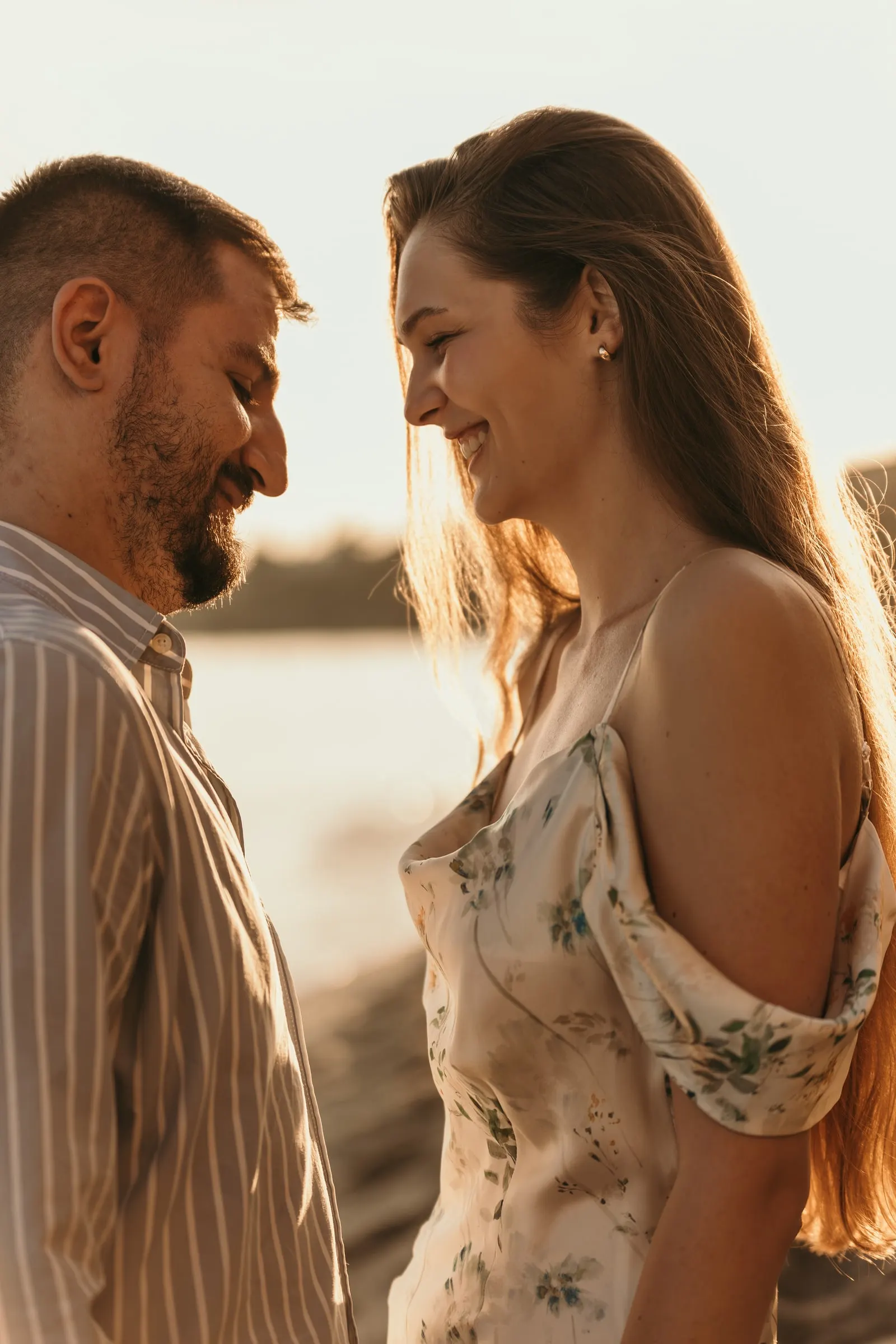 Close portrait of the couple smiling at each other in warm evening light, beach in Nerja