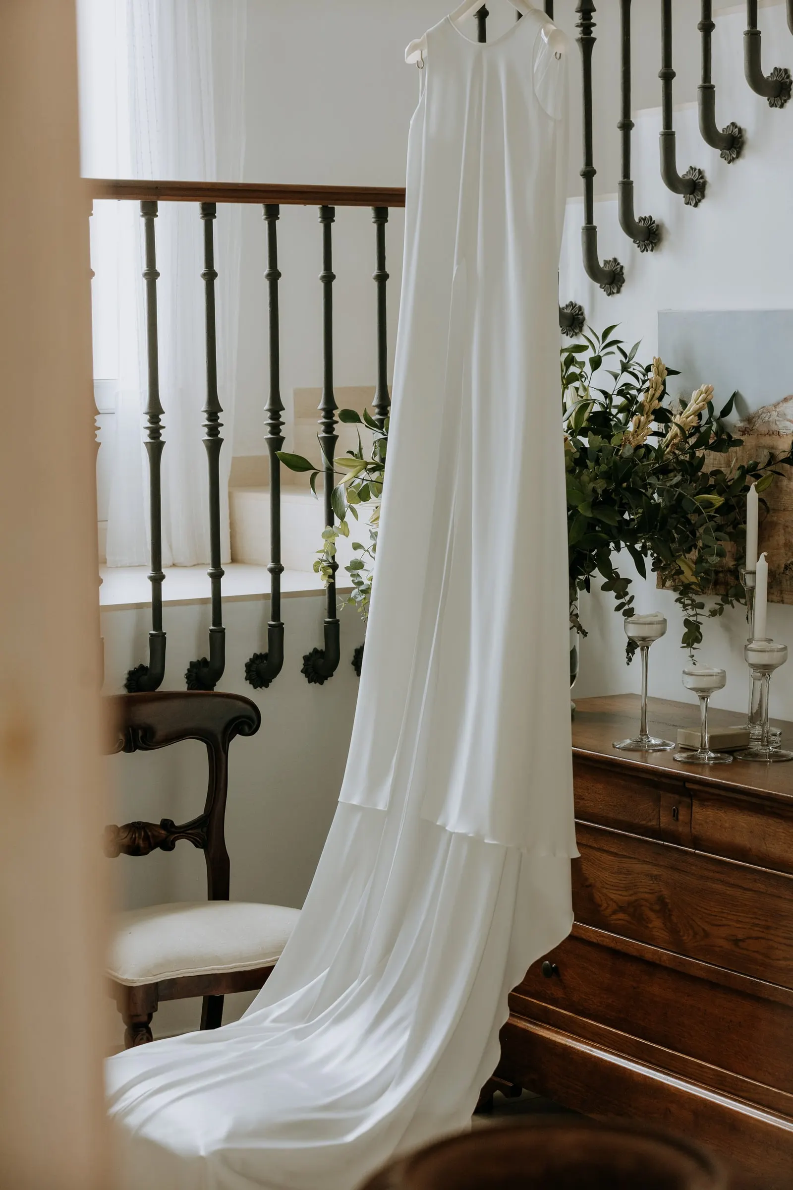 Wedding dress hanging by a wooden staircase in the family home, Sotogrande