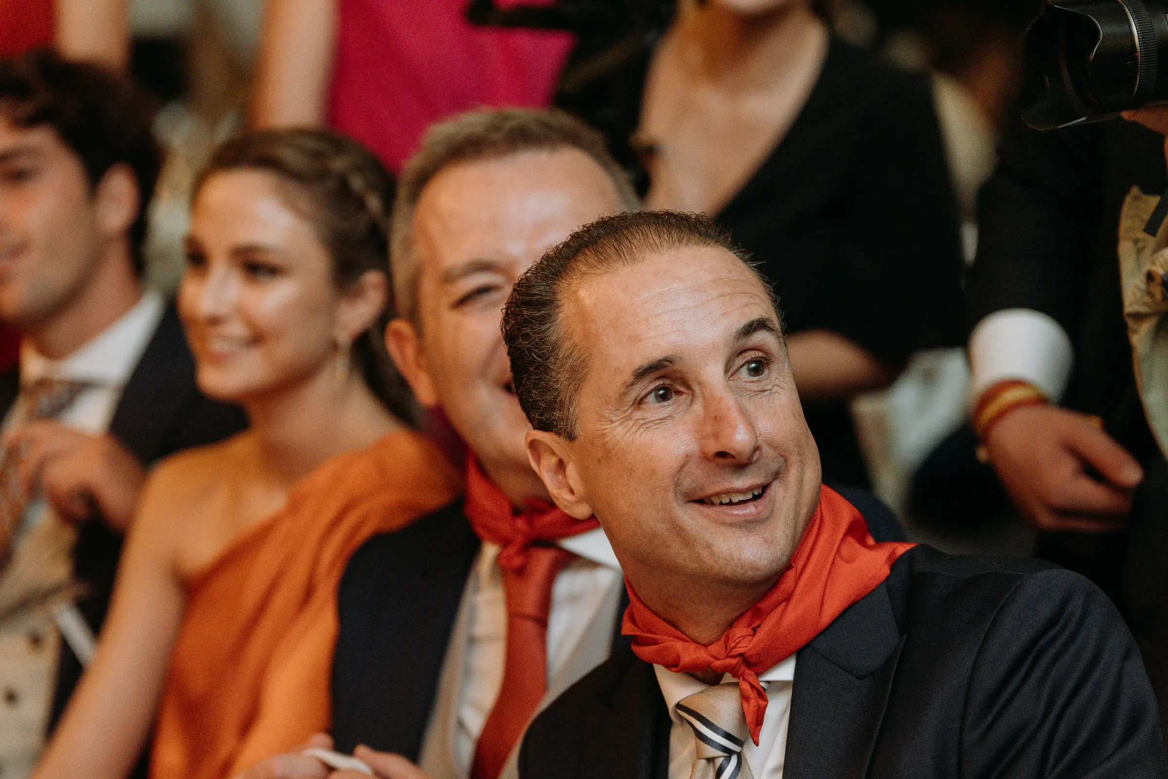 Guests in red neckerchiefs laughing at the dinner table in Sotogrande