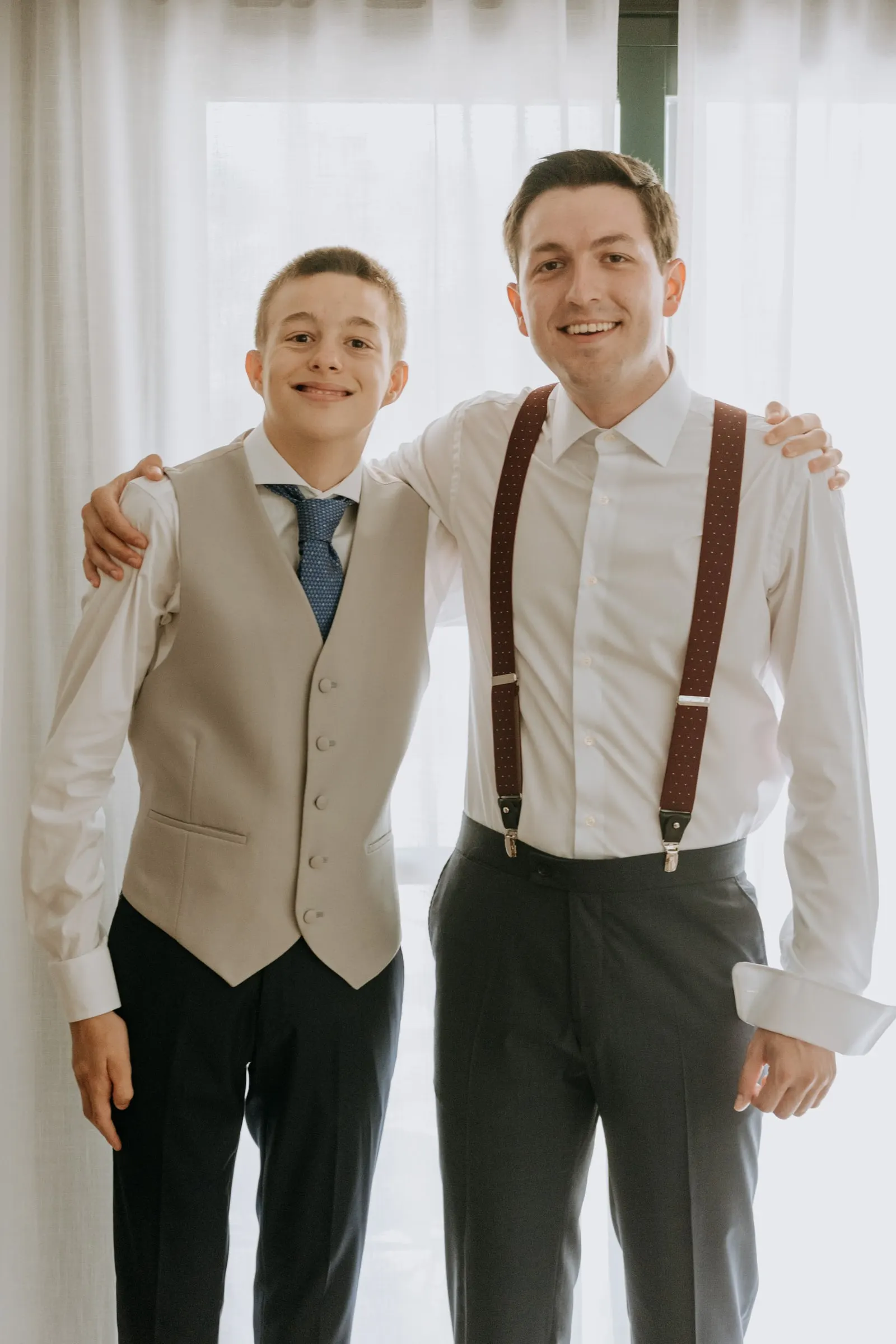 Groom and his younger brother side by side, arms round each other, before the wedding in Sotogrande