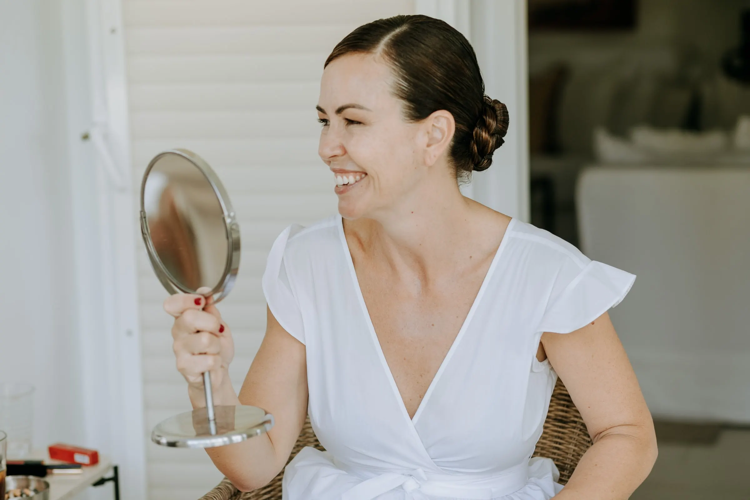 Guest laughing with a hand mirror while she gets ready