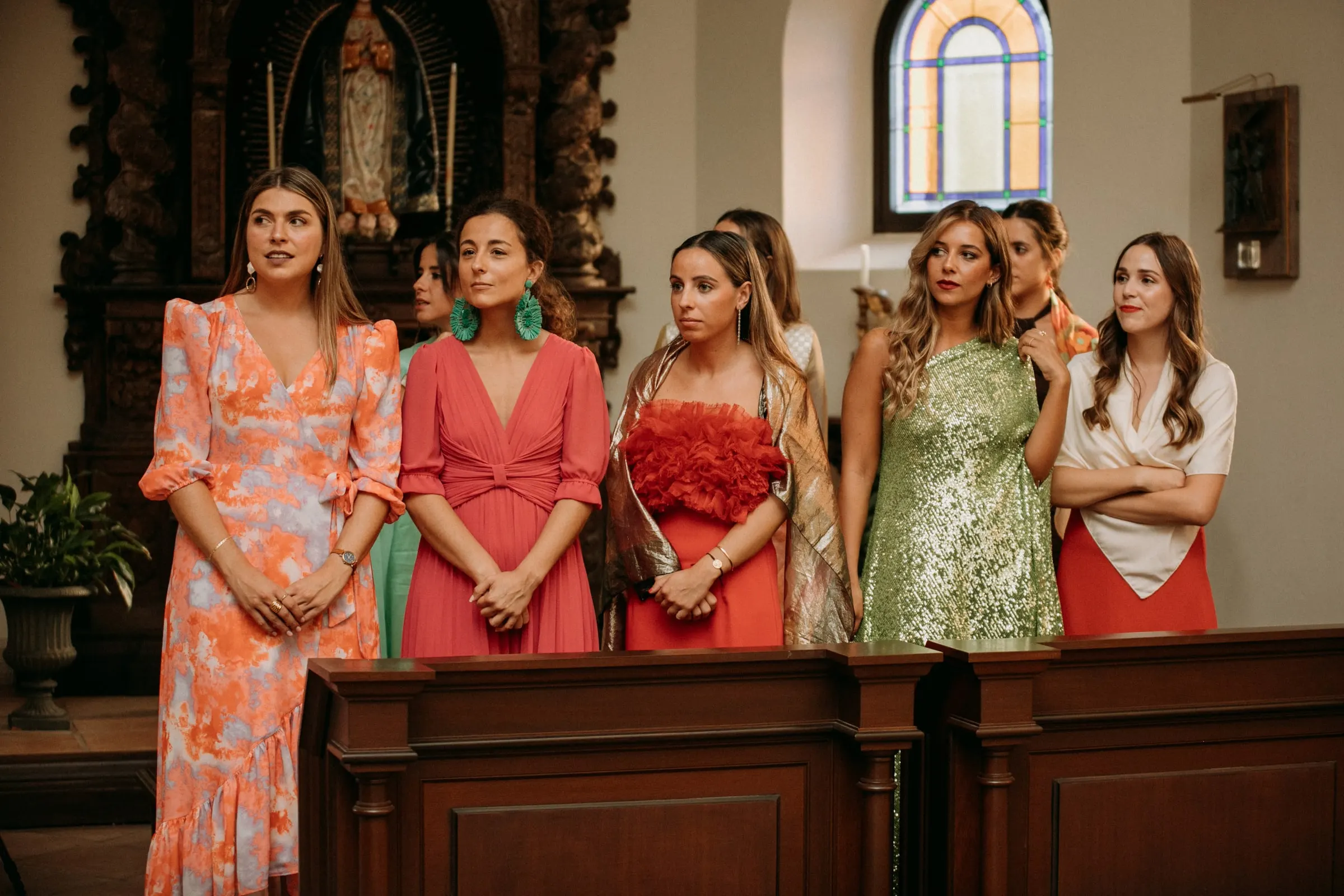 Guests in bright summer dresses standing in the pews