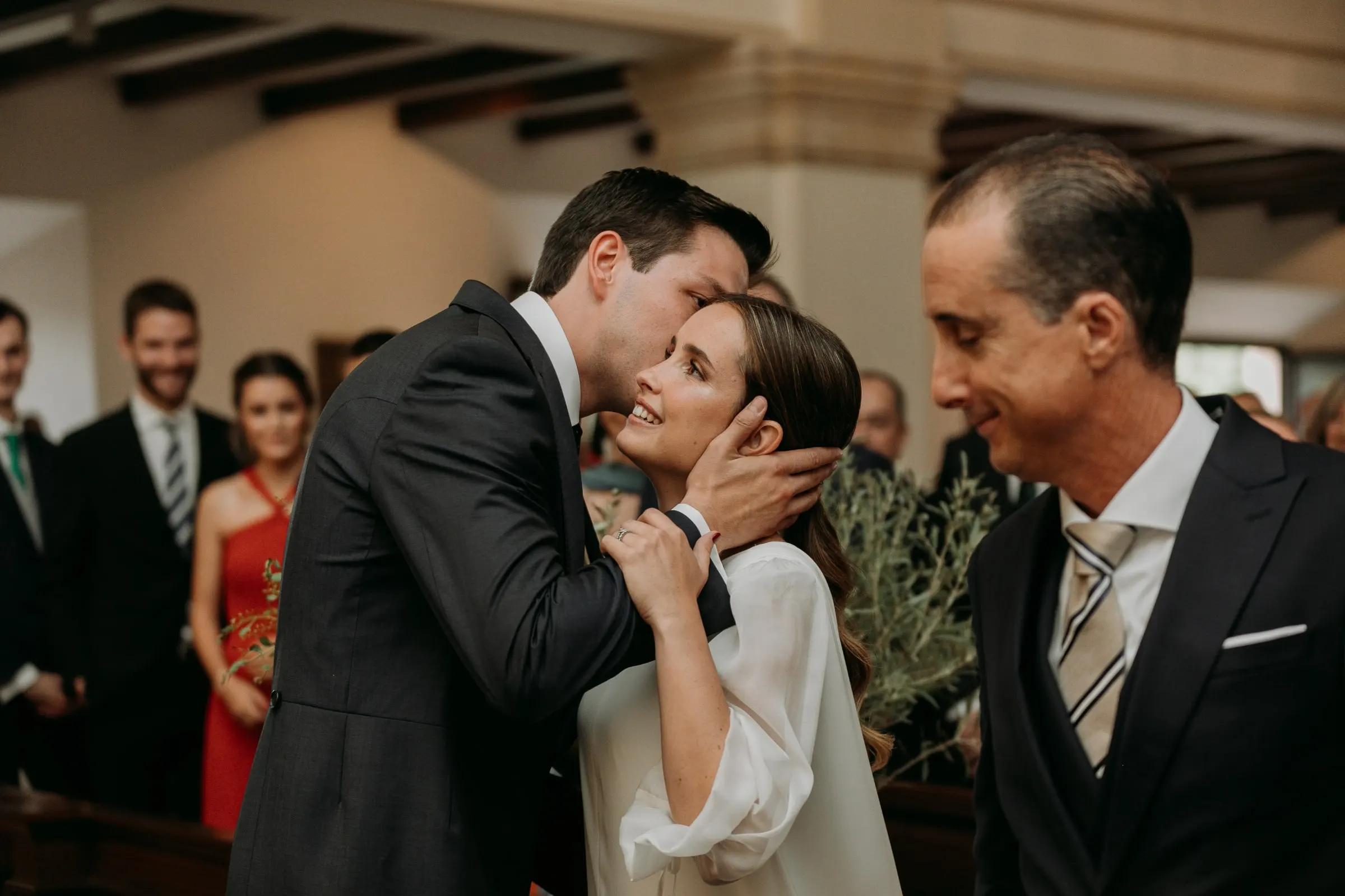 Groom kissing the bride as she reaches the altar