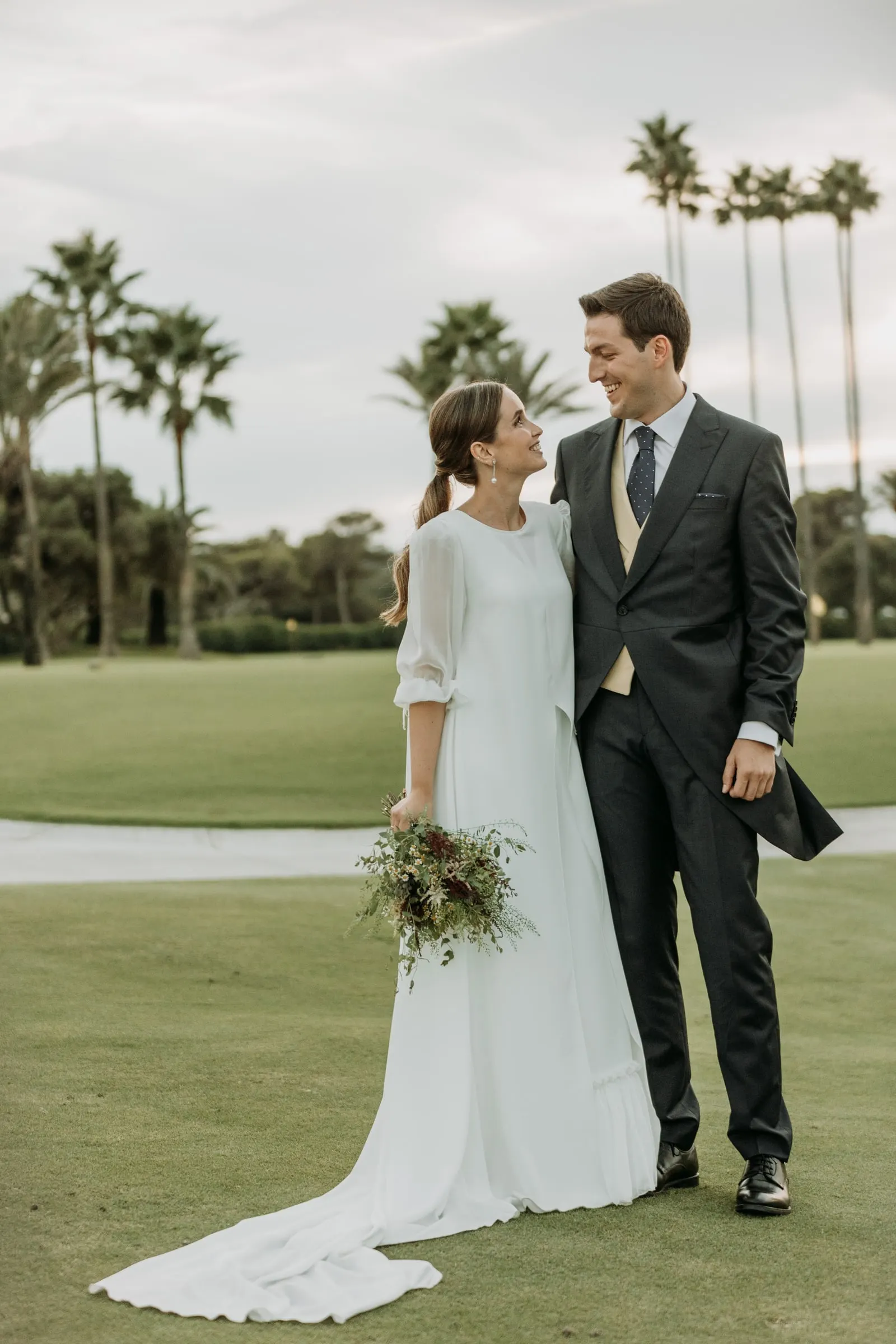 Los novios en un campo de golf bordeado de palmeras en Sotogrande
