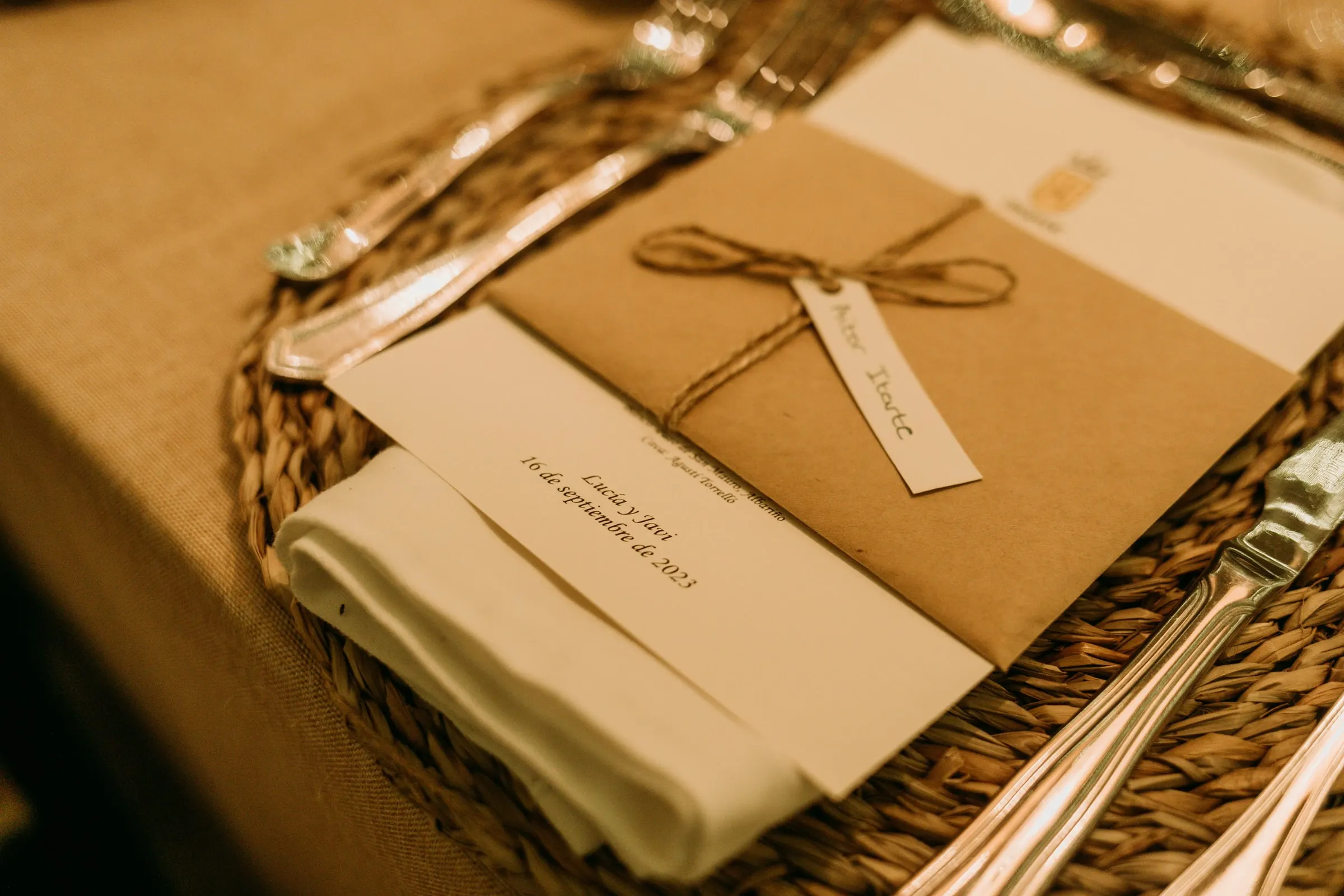 Place setting with a kraft envelope, name tag and menu card dated 16 September 2023