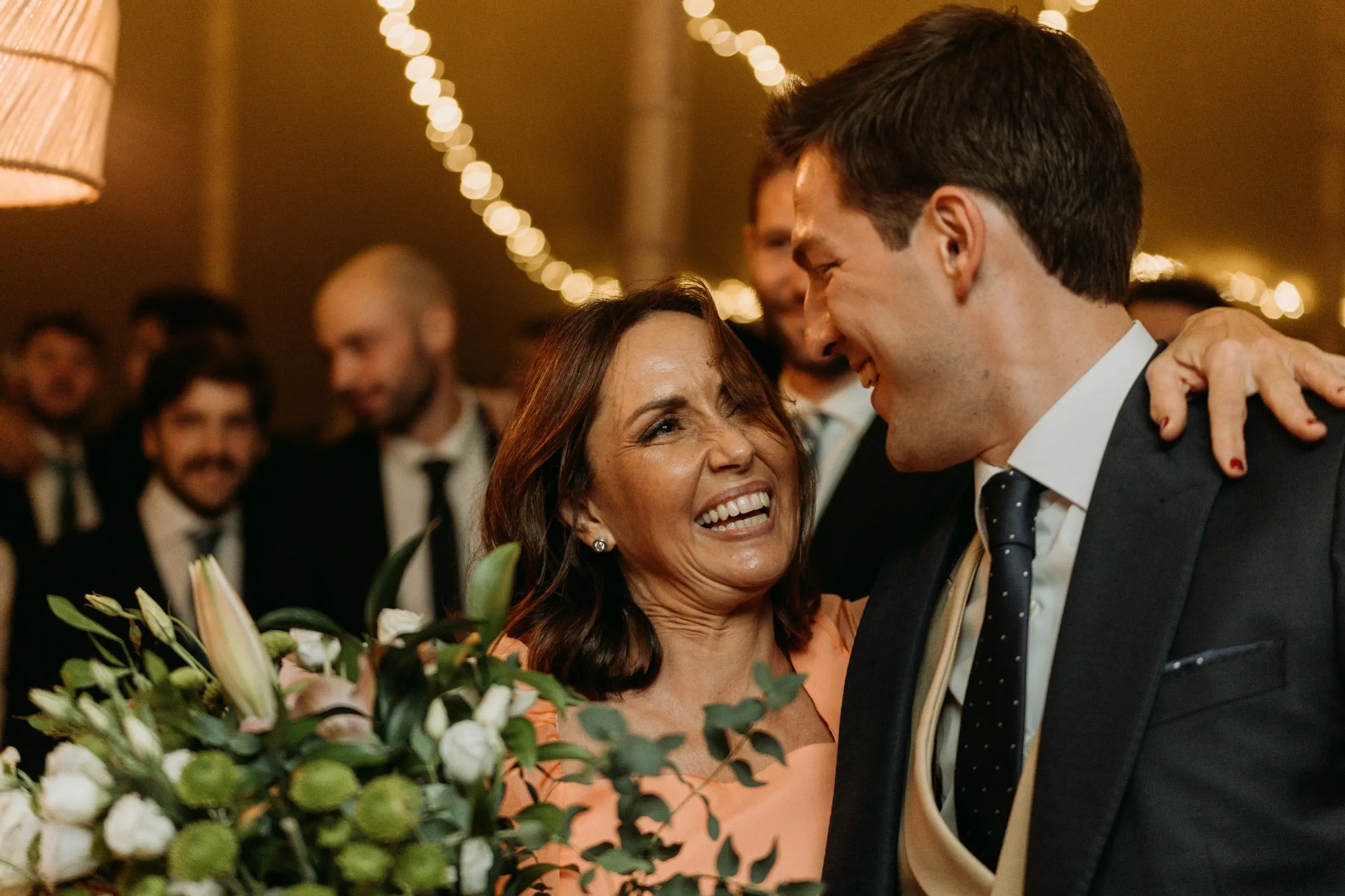 Groom hugging a guest at the dinner tables