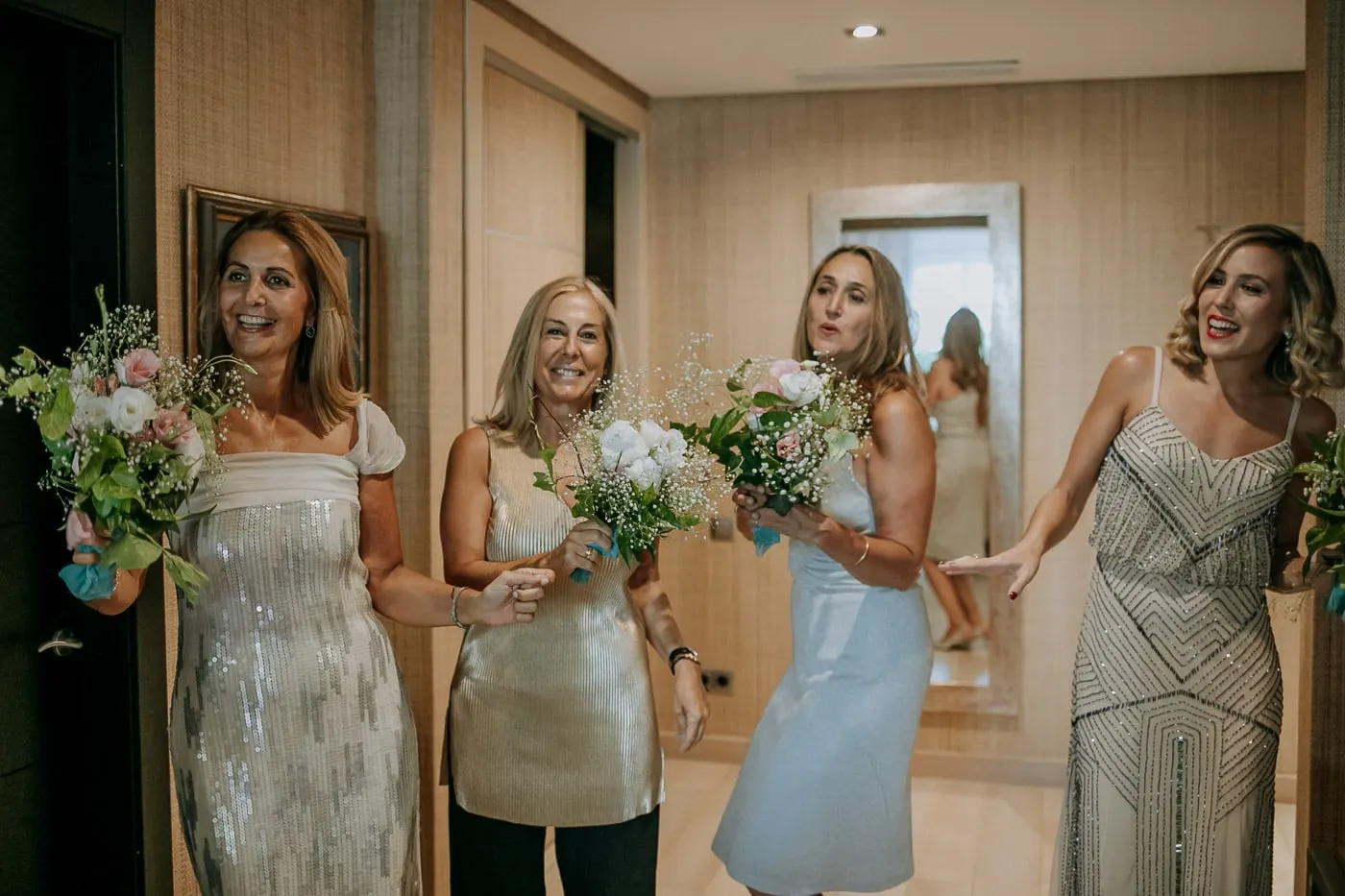 Las amigas, con sus ramitos, ven a la novia vestida por primera vez