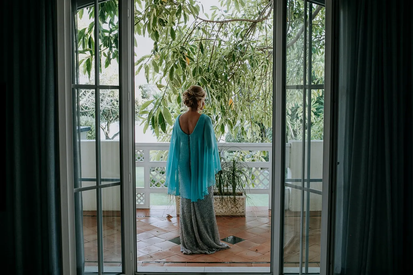 La novia, con su capa turquesa, sale al balcón