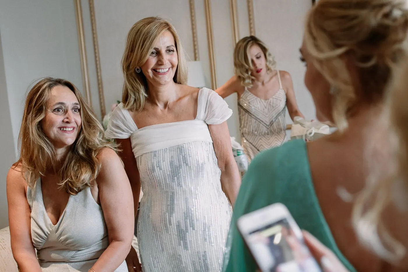 Las amigas sonríen a la novia mientras se arregla
