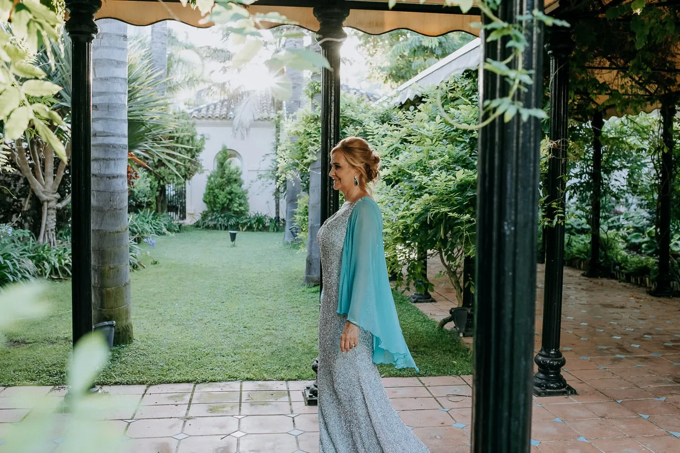 La novia mira el jardín desde la pérgola