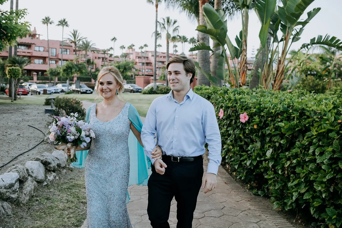 La novia avanza por el camino del jardín entre palmeras, Tikitano