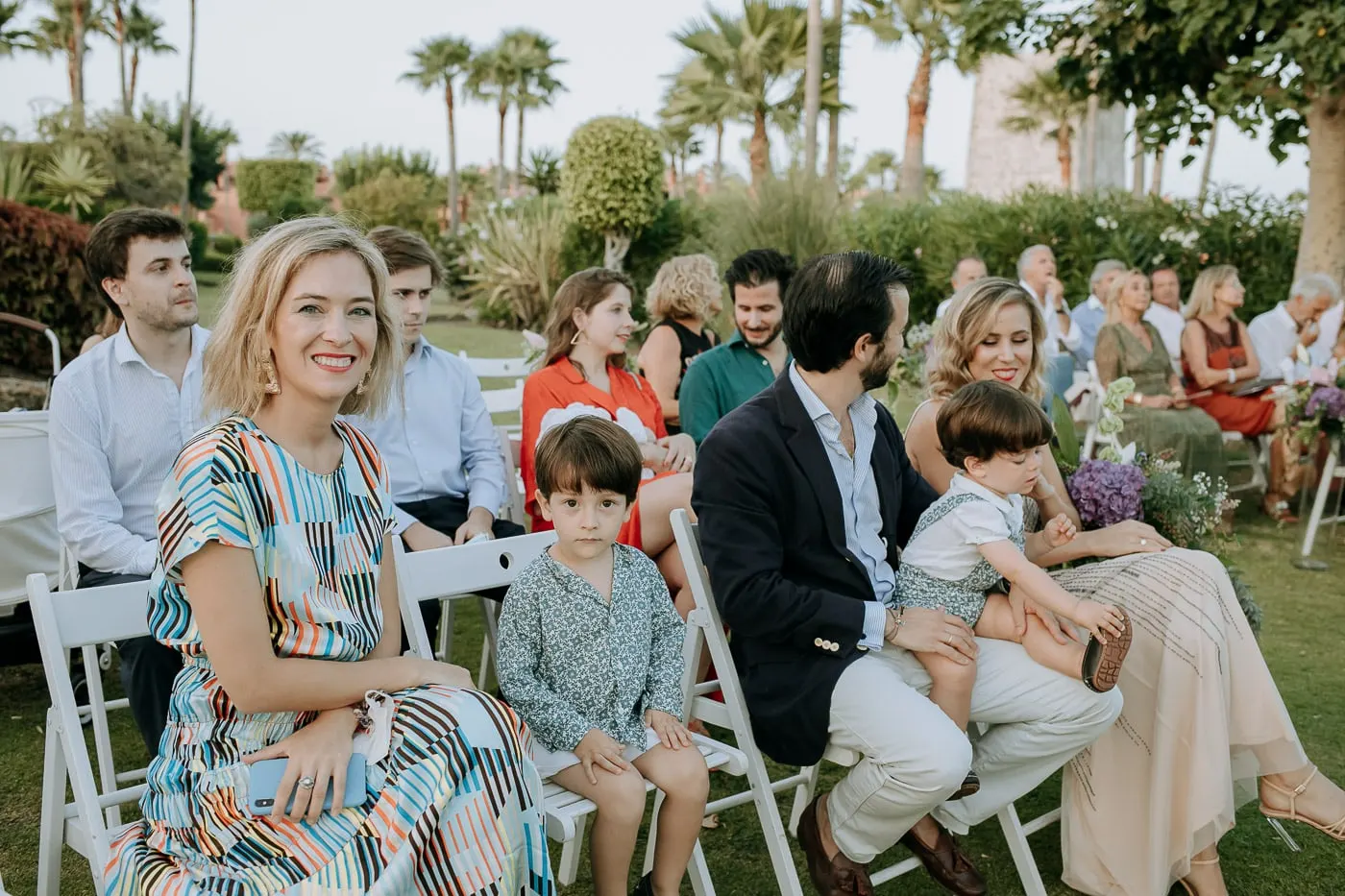 Invitados sonrientes en las filas de sillas blancas, Estepona