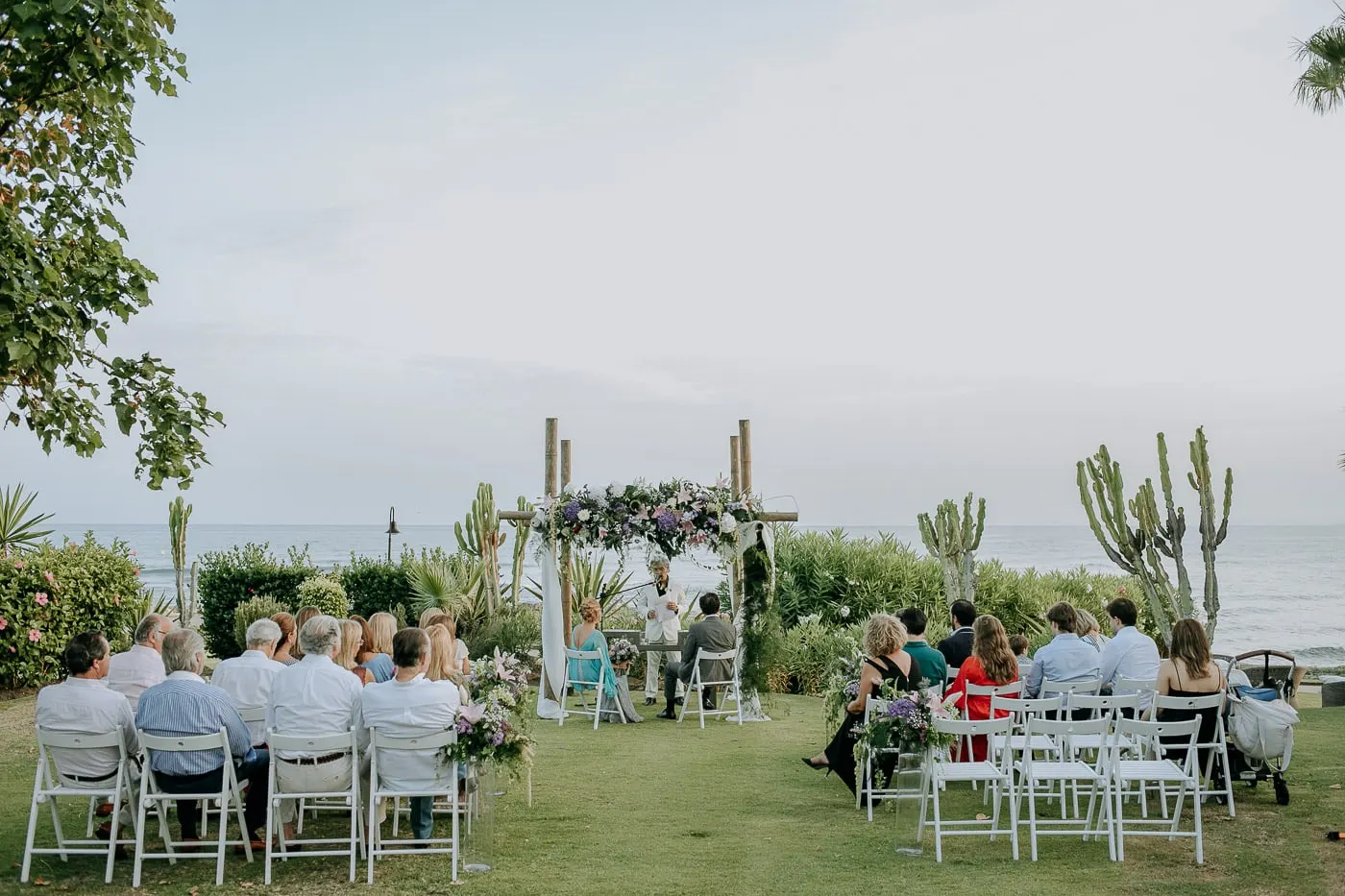 La ceremonia del jardín desde las últimas filas, con el mar y los cactus tras el arco
