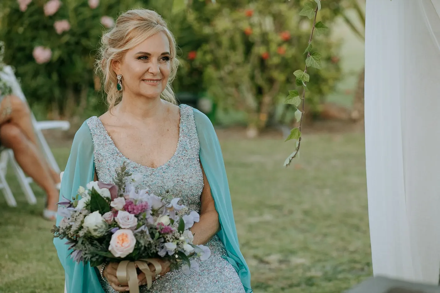 La novia sonríe con su ramo durante la ceremonia