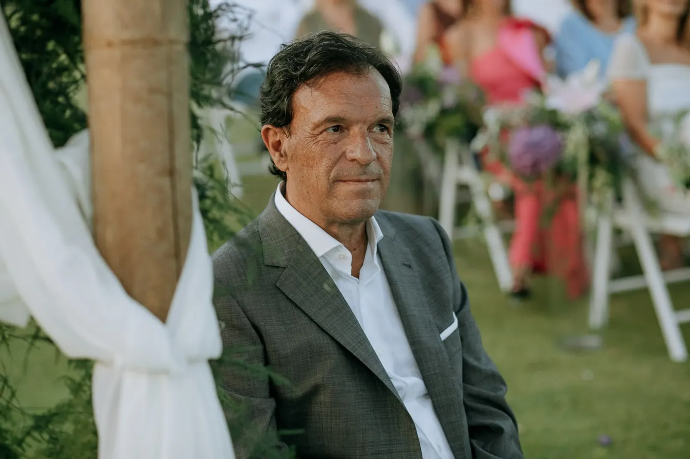 El novio escucha la ceremonia enmarcado por telas blancas