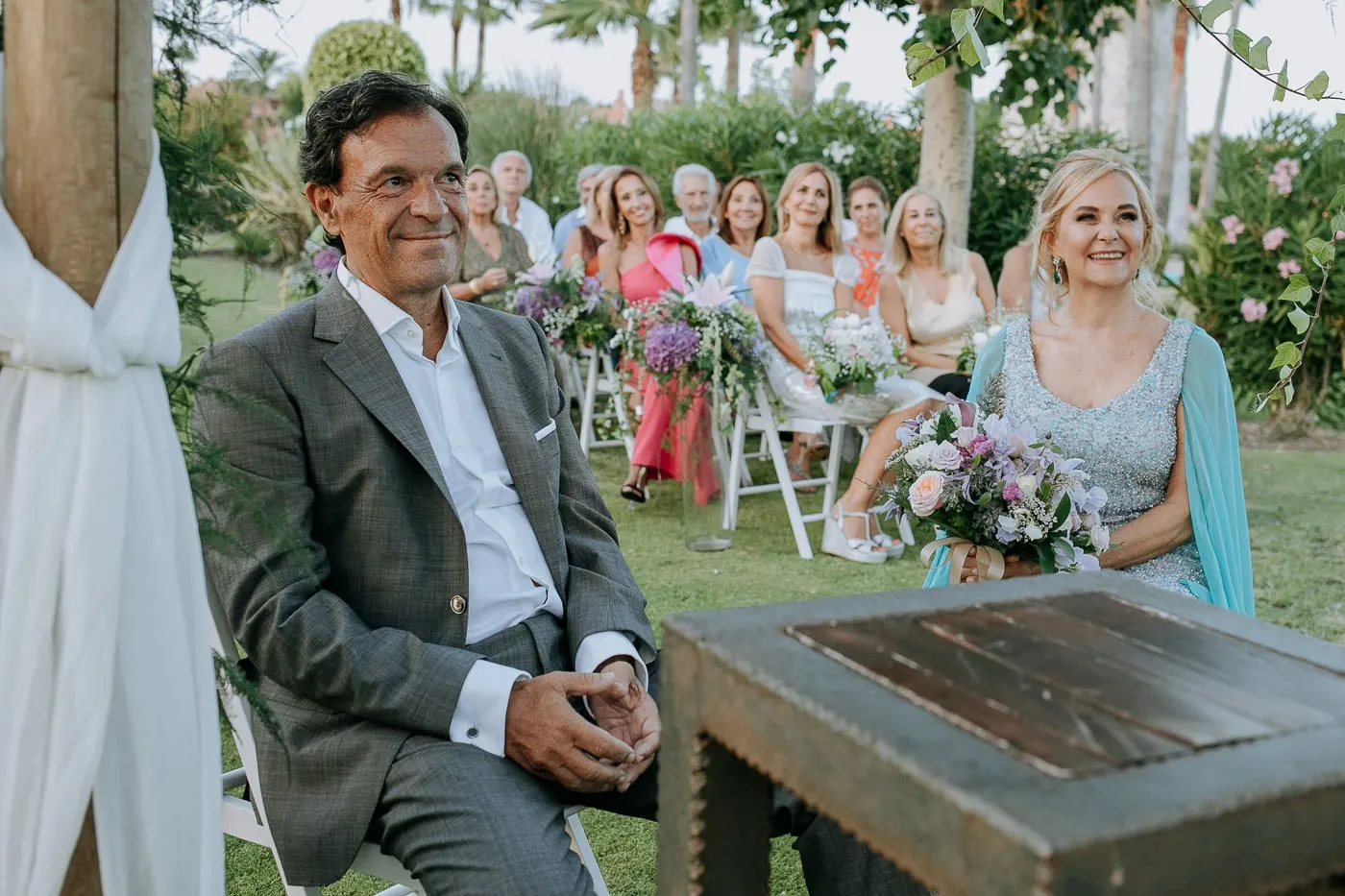 Los novios sonríen en sus sillas ante los invitados, Estepona