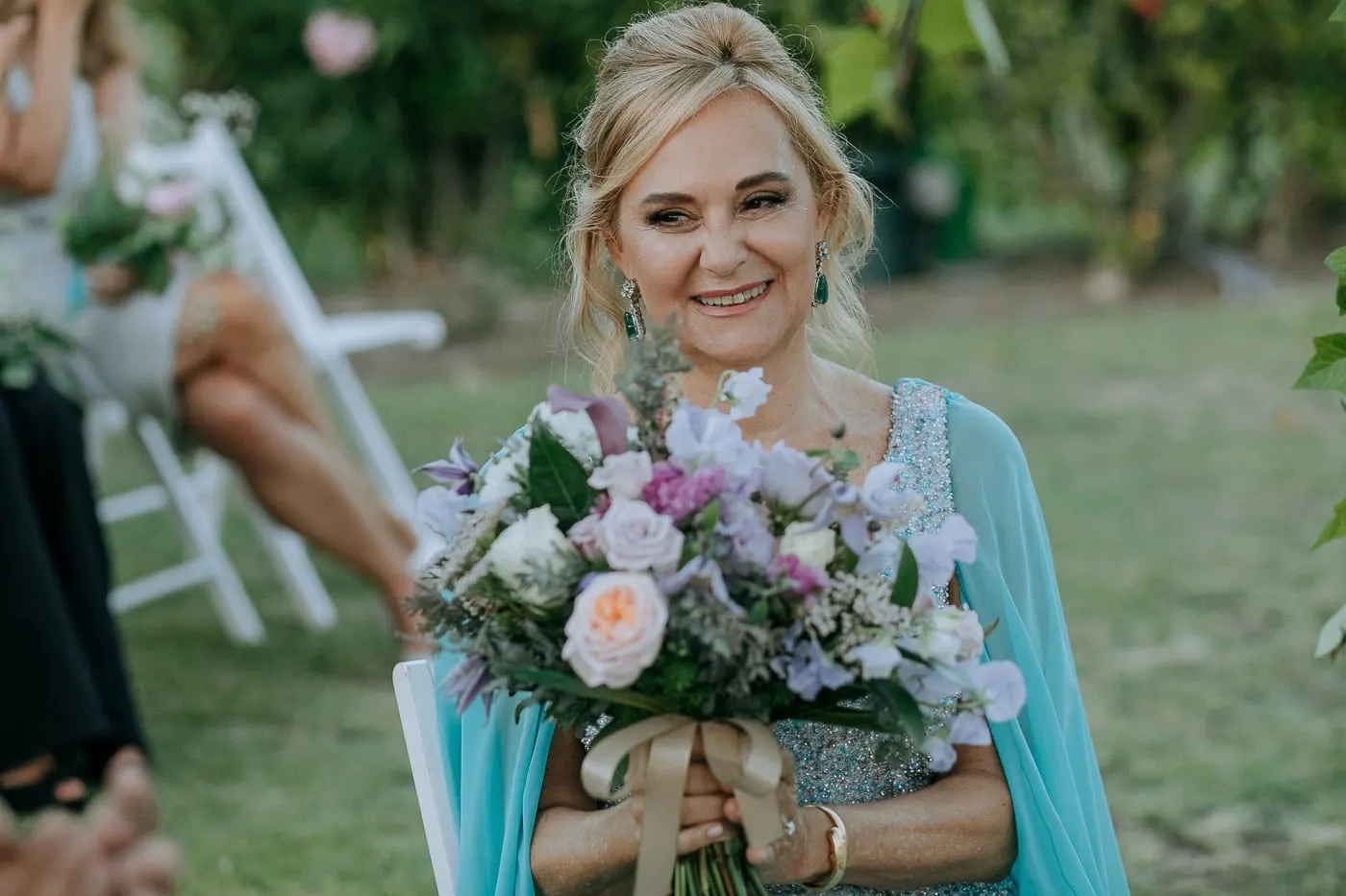 La novia sonríe con su ramo en el jardín
