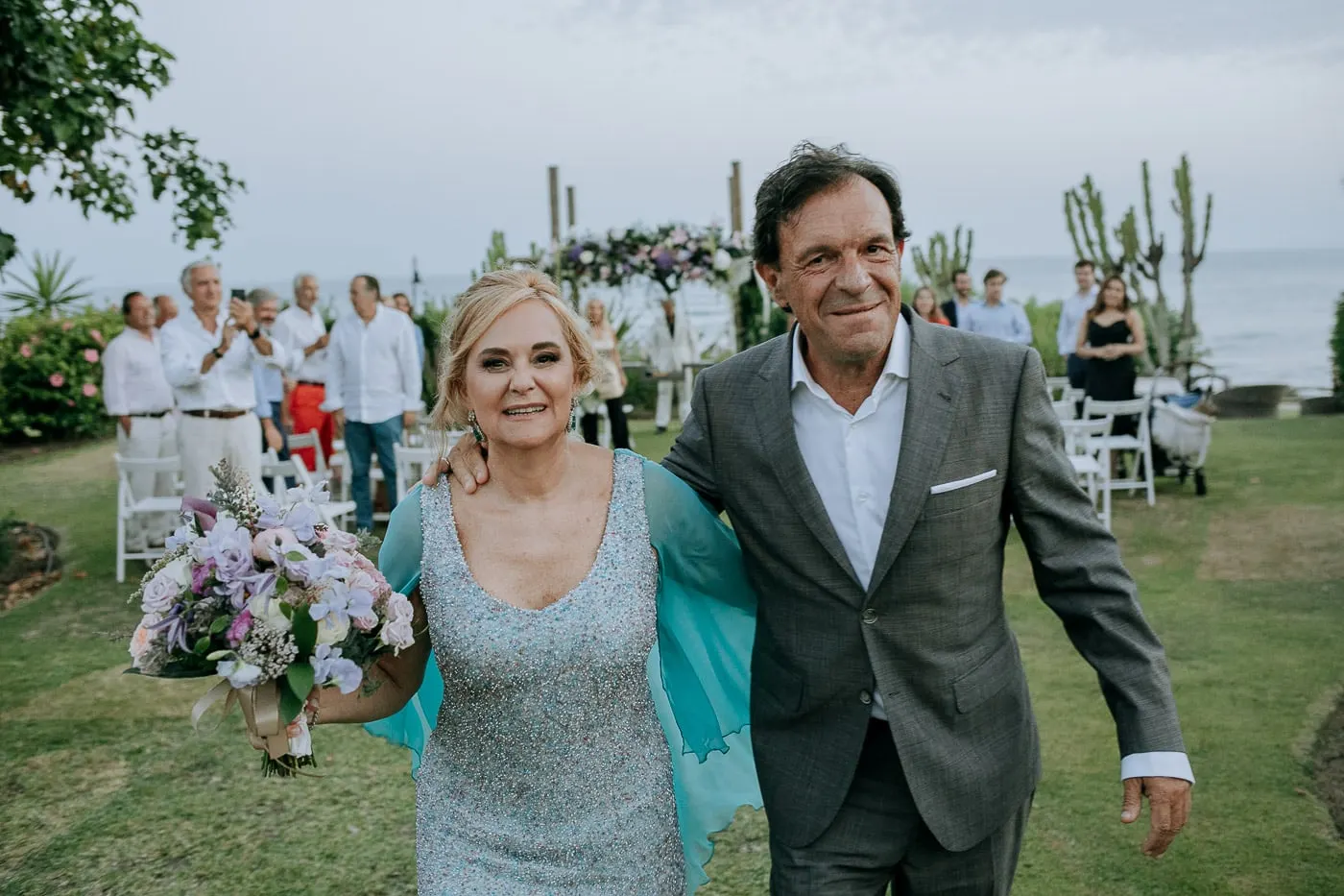 Los recién casados sonríen abrazados con los invitados detrás, Estepona