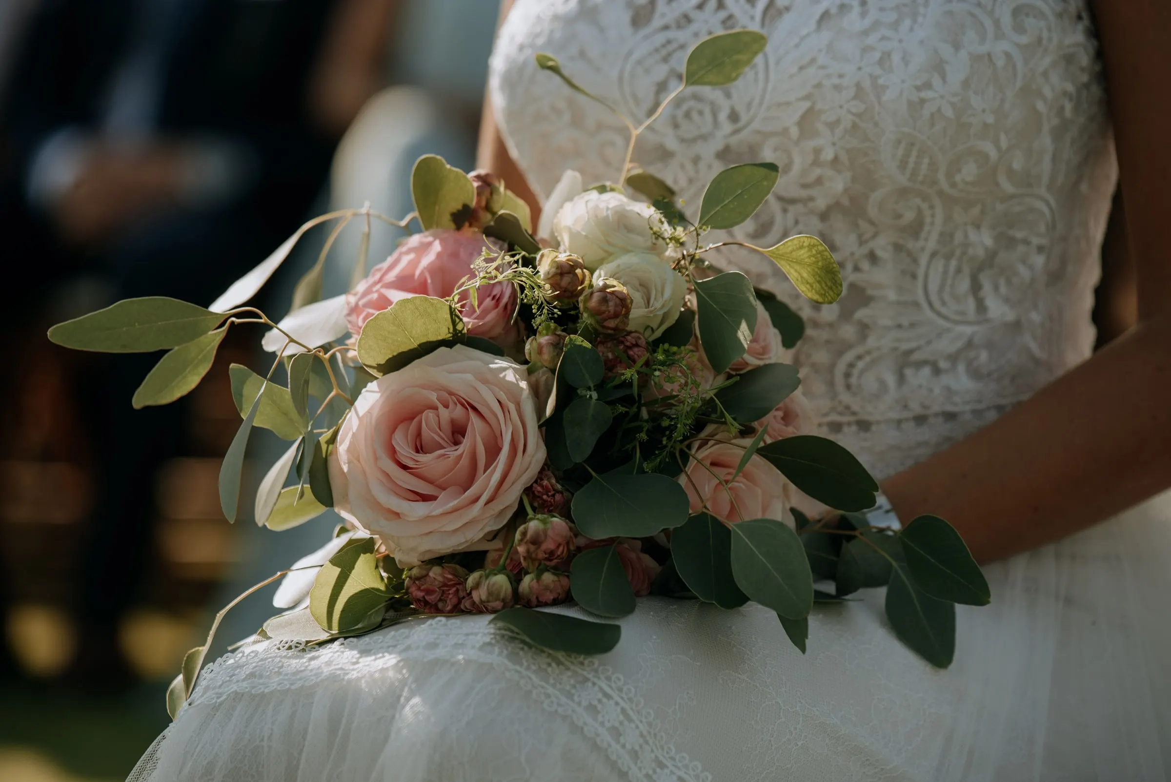 Detalle del ramo de rosas rosas y eucalipto sobre el vestido de encaje, Trocadero, Sotogrande