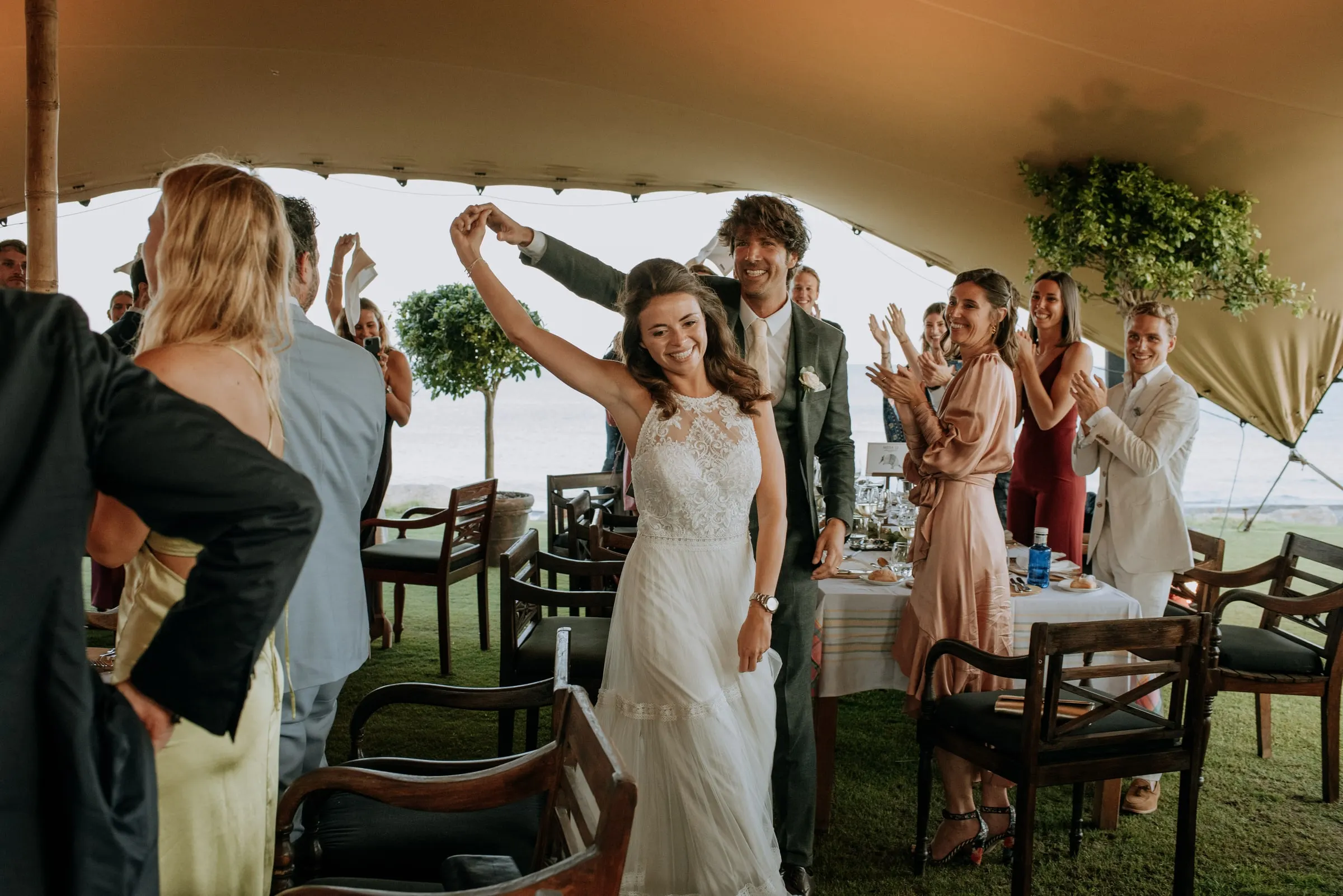 La novia baila con el brazo en alto mientras los invitados aplauden bajo la carpa, Trocadero, Sotogrande