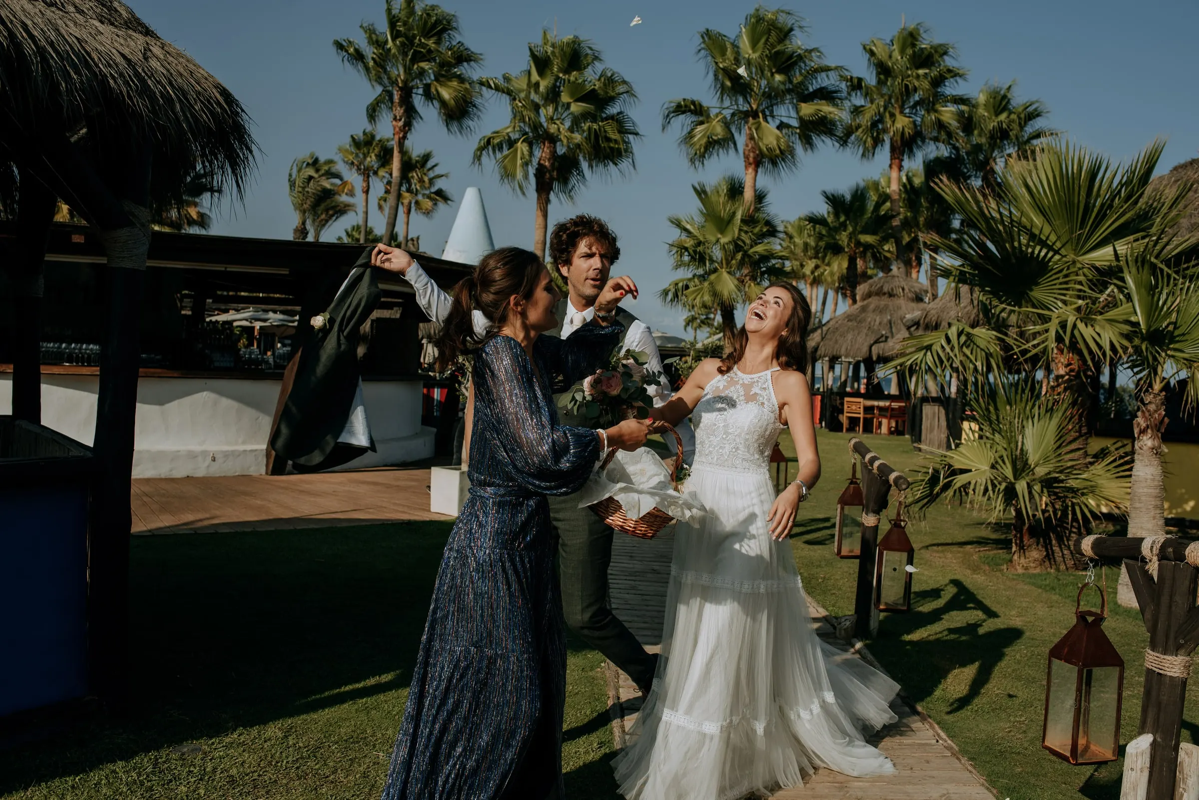 La novia baila con una invitada en el césped entre palmeras, Trocadero, Sotogrande