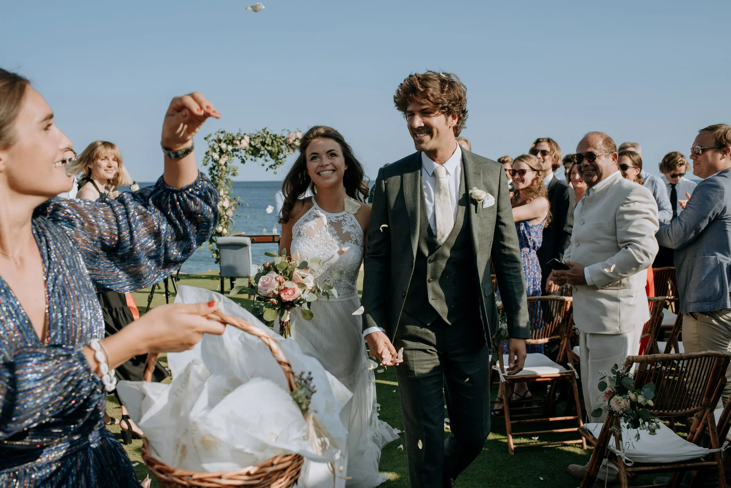 Una invitada lanza pétalos de una cesta al paso de los recién casados, Trocadero, Sotogrande