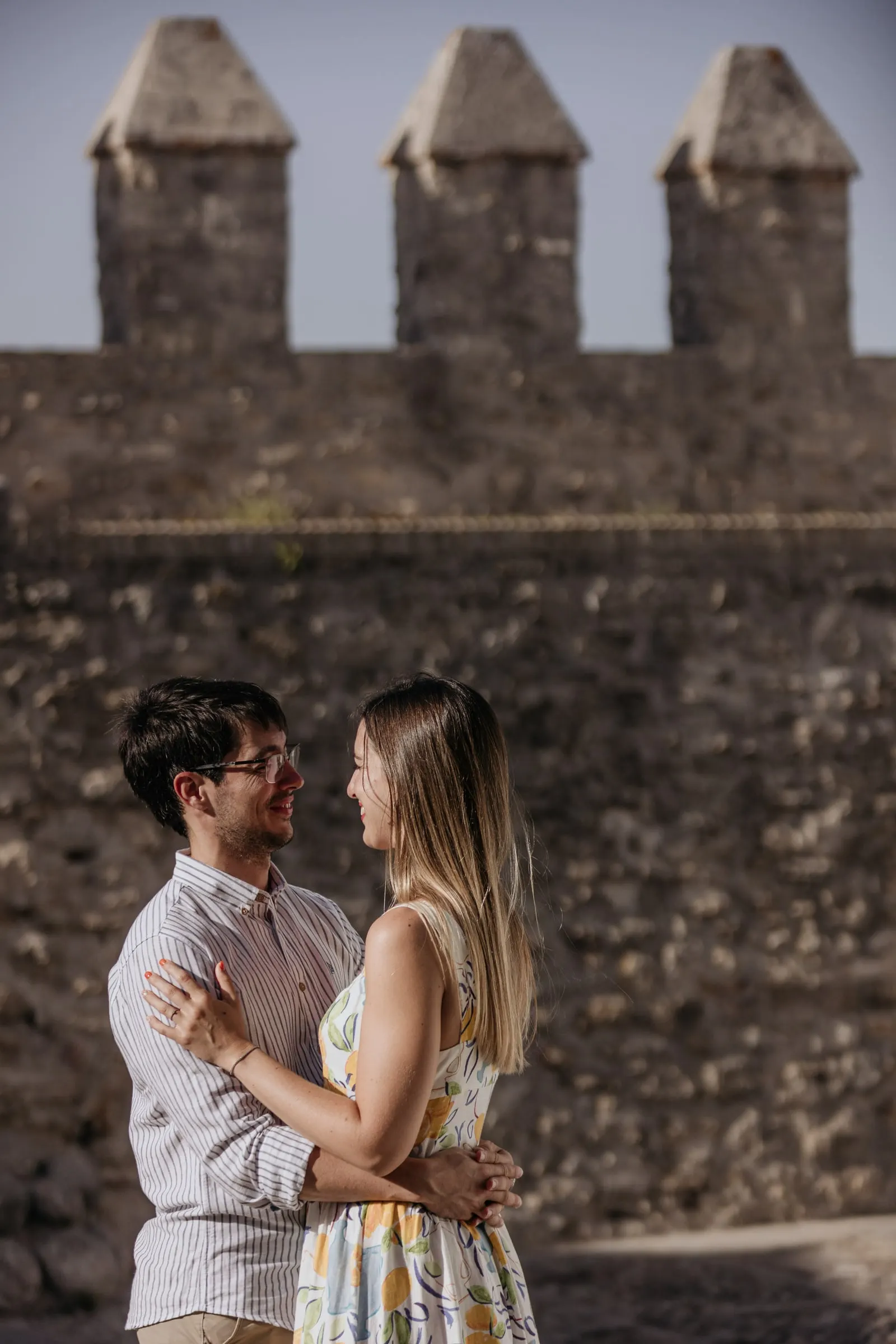 Los prometidos abrazados bajo las almenas del castillo de Vejer